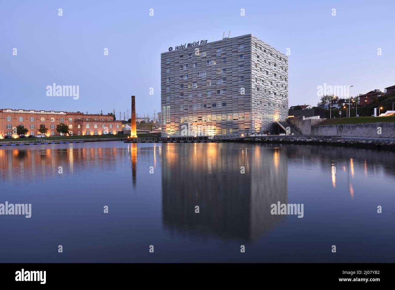 Das moderne Hotel Melia Ria und das Kongresszentrum (ehemaliges Fabrikgebäude) spiegeln sich in der Abenddämmerung im Canal do Cojo, Aveiro Portugal, wider. Stockfoto
