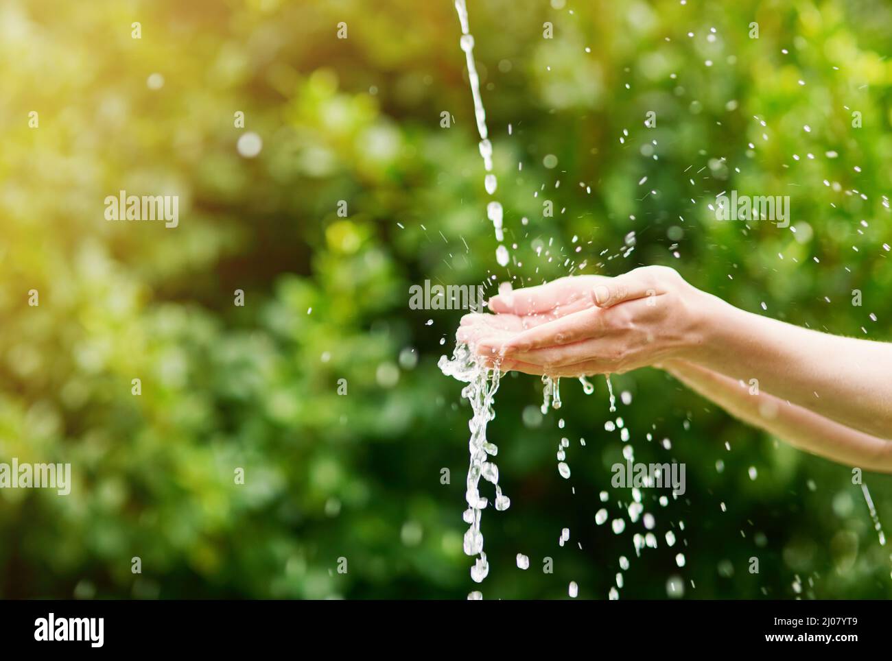 Schützen Sie die Natur und ihre Ressourcen. Ein Handschuss, der unter einem Wasserstrom ausgestreut wurde. Stockfoto