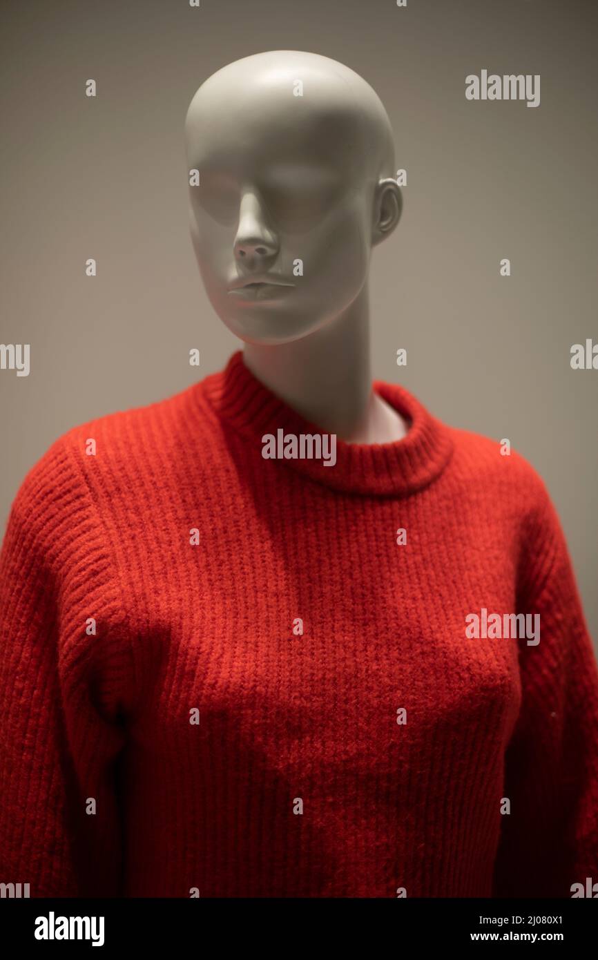 Schaufensterpuppe in einem roten Pullover. Schaufenster. Kleidung mit Wollbindung. Frauen-Schaufensterpuppe ohne Haare. Stockfoto