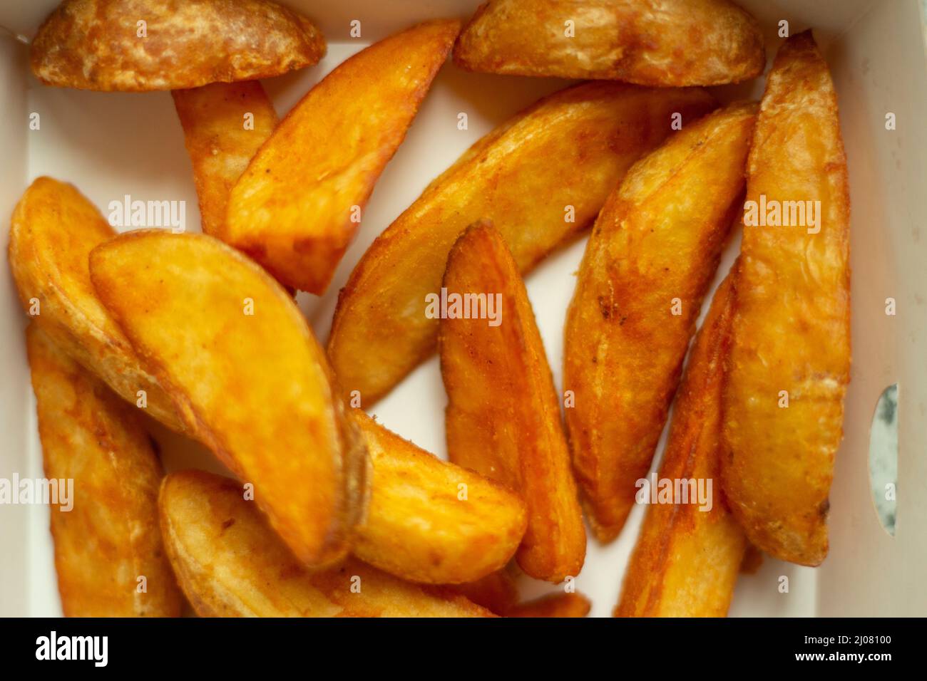Die Textur der Kartoffeln ist rustikal. Chips. Fetthaltige Lebensmittel. Details zu Fast Food. Stockfoto