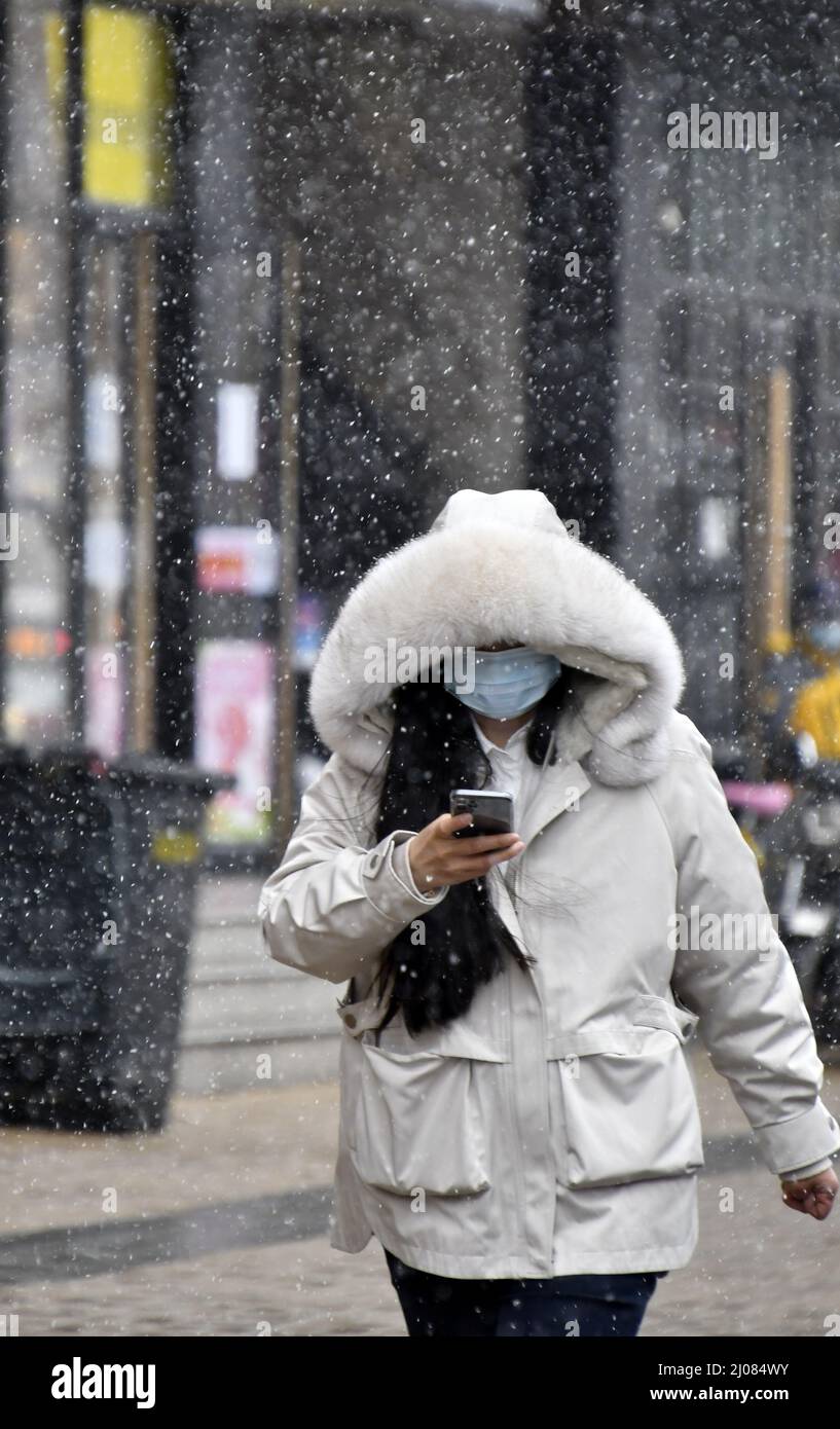 (220317) -- PEKING, 17. März 2022 (Xinhua) -- Ein Bürger läuft im Schnee in Peking, der Hauptstadt Chinas, 17. März 2022. Chinas meteorologische Behörden gaben am Donnerstag eine blaue Warnung für schweren Schnee im nördlichen Teil des Landes aus. (Xinhua/Li Xin) Stockfoto