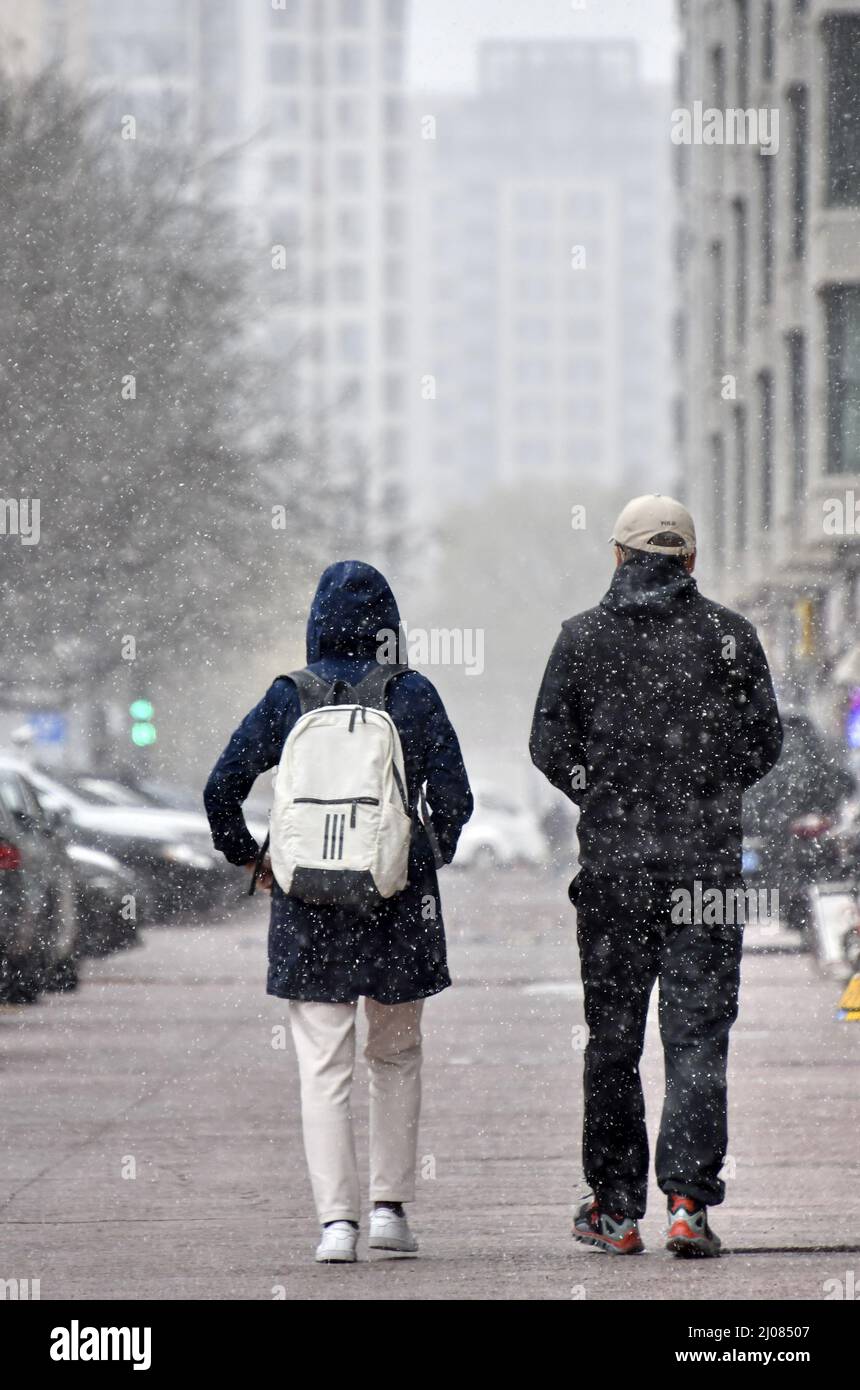 (220317) -- PEKING, 17. März 2022 (Xinhua) -- Menschen laufen im Schnee in Peking, der Hauptstadt Chinas, 17. März 2022. Chinas meteorologische Behörden gaben am Donnerstag eine blaue Warnung für schweren Schnee im nördlichen Teil des Landes aus. (Xinhua/Li Xin) Stockfoto