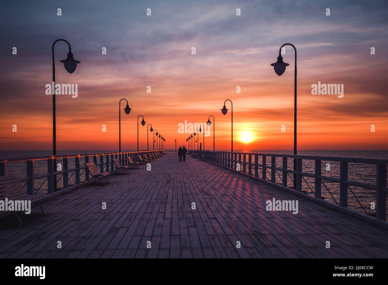 Wunderschöne Landschaft am Morgen am Meer. Hölzerner Pier mit einem bunten Himmel in Gdynia, Polen. Stockfoto