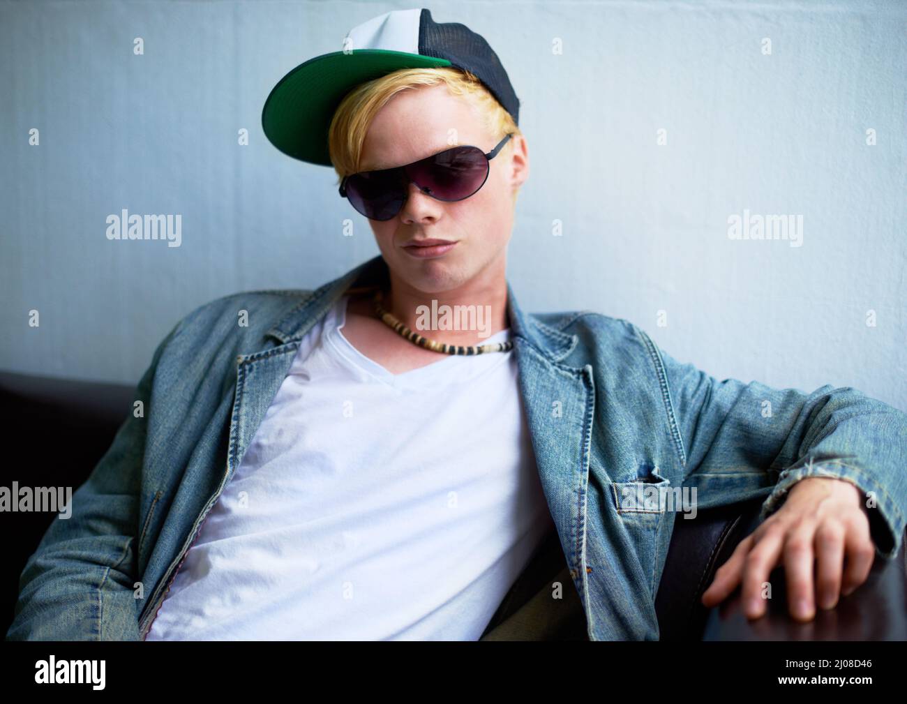 Urbane Einstellung. Attraktive junge blonde Kerl trägt Straße-Stil Kleidung und ein Grinsen. Stockfoto