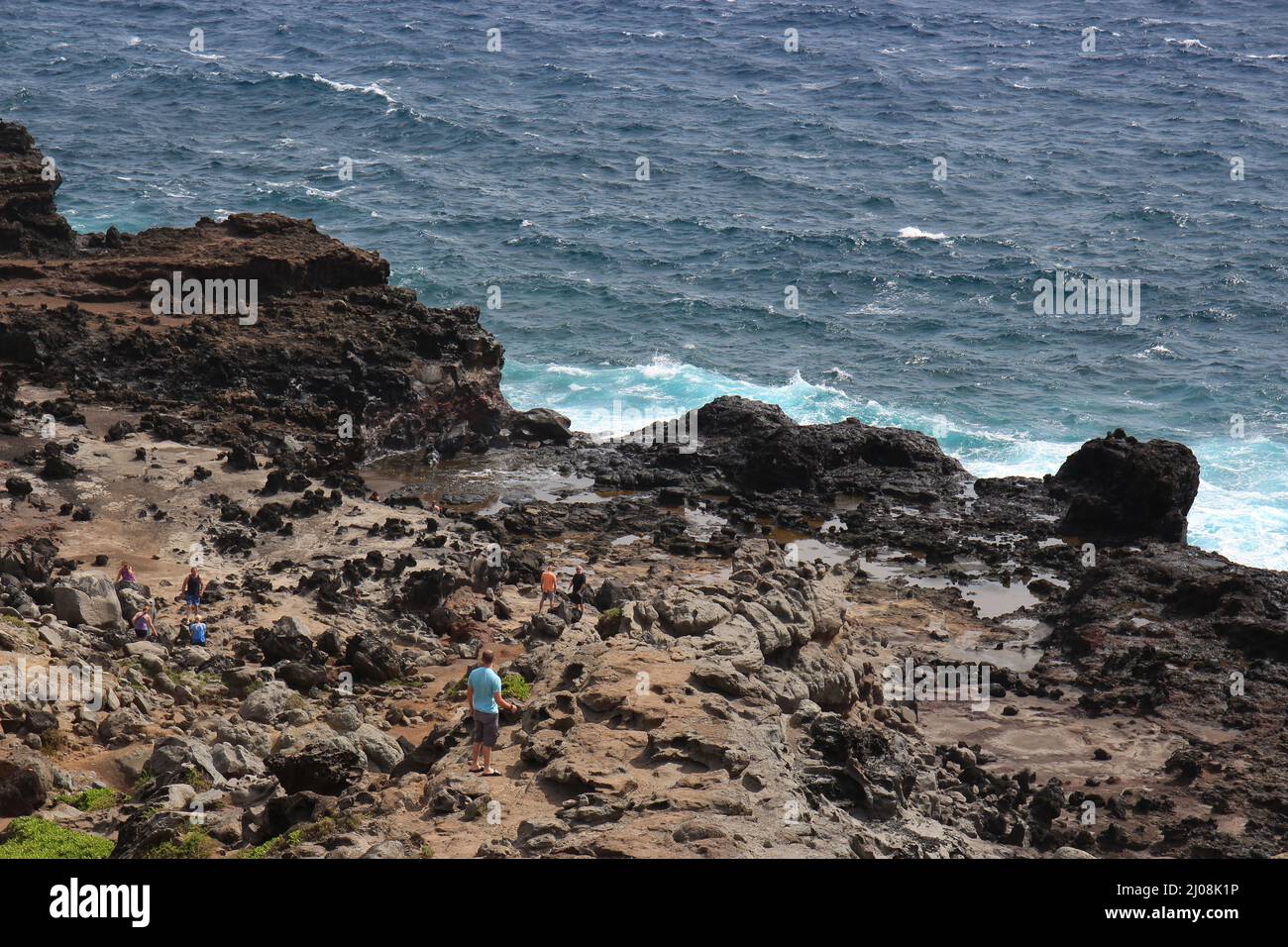 Eine raue, desolate Landschaft auf Maui, die zum Nakalele Blowhole und zur Poelua Bay führt, wo Touristen die Gegend erkunden Stockfoto
