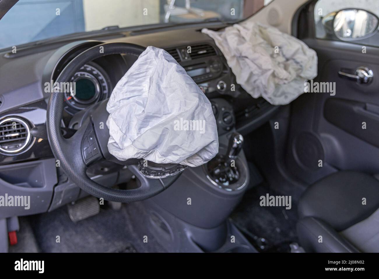 Offene Airbags bei frontalem Verkehrsunfall eines Kleinwagens Stockfoto