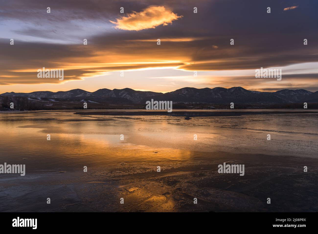 Sonnenuntergang am Winter Lake - Ein goldener Sonnenuntergang im Winter am gefrorenen Bear Creek Lake, Denver-Lakewood, Colorado, USA. Stockfoto