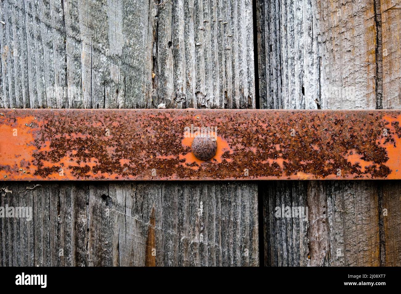 Verwitterter Eisenstreifen an der alten Holztür. Rostige Details. Stockfoto