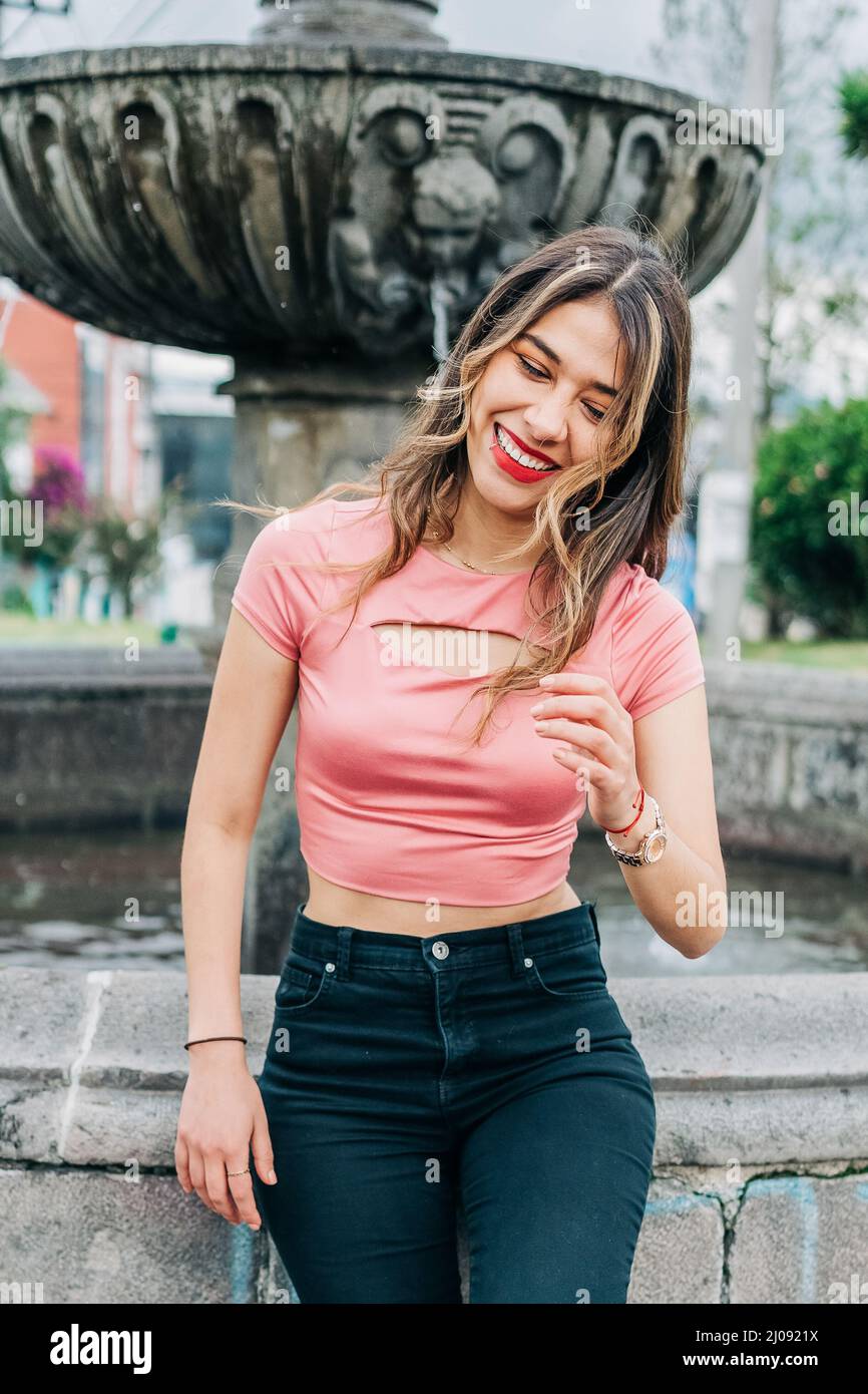 Lächelnd attraktive junge latinerin mit ihren langen blonden Haaren, trägt sie Make-up mit roten Lippen und Schatten, Mode und Schönheit Stockfoto