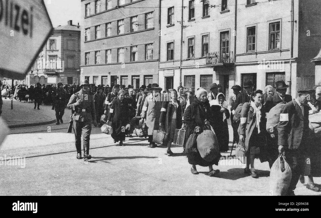 Deutsch besetzte Polen. Eine Kolonne von gefangenen Juden marschiert mit Bündeln entlang der Hauptverkehrsstraße in Krakau während der Liquidierung des Ghettos von Krakau. SS-Wachen überwachen die Deportation in die Vernichtungslager. Stockfoto
