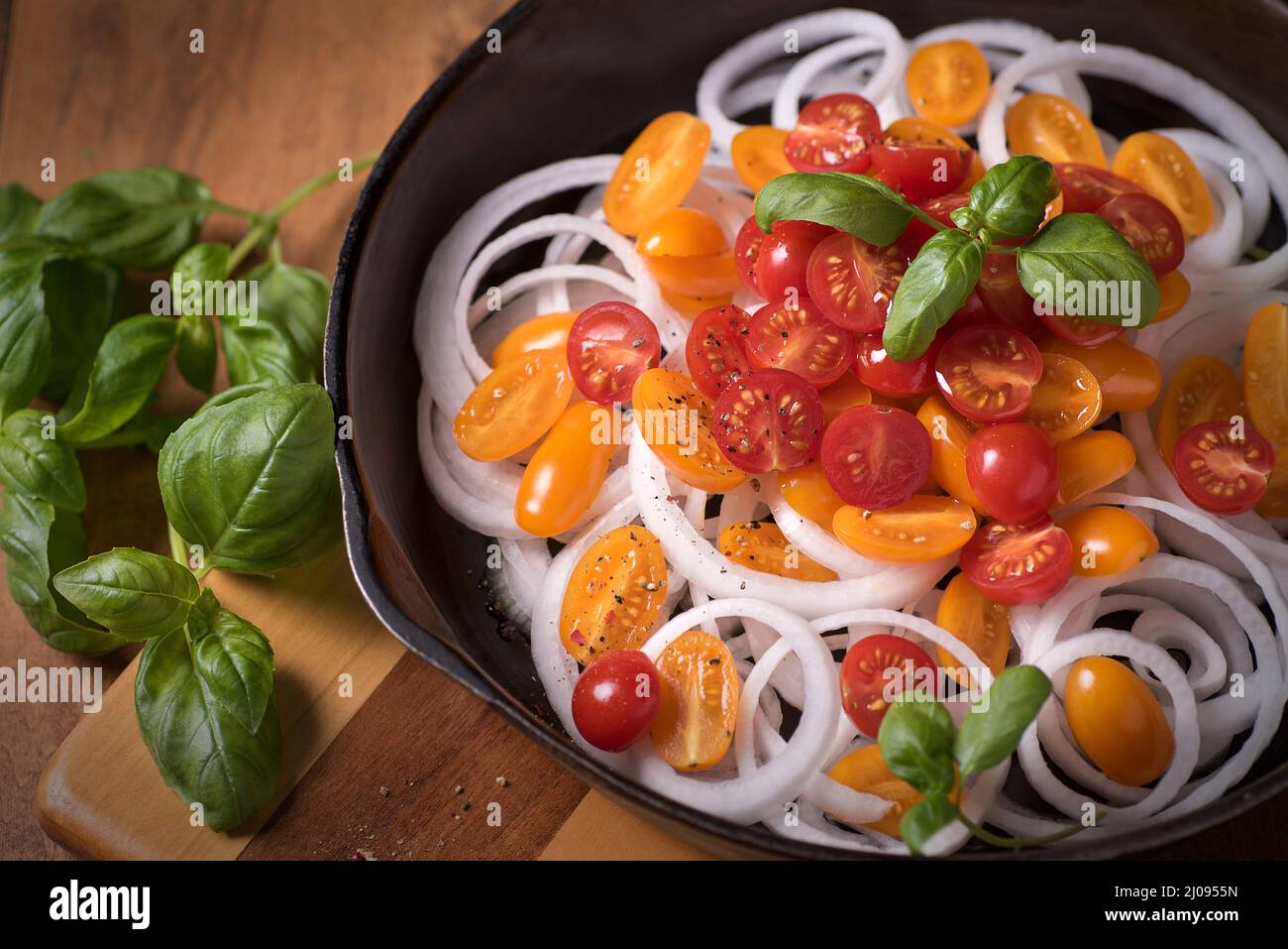 Appetitliche Zubereitung einer hausgemachten Tomatensauce mit frischem Gemüse und Basilikum. Schöne helle Farben. Stockfoto