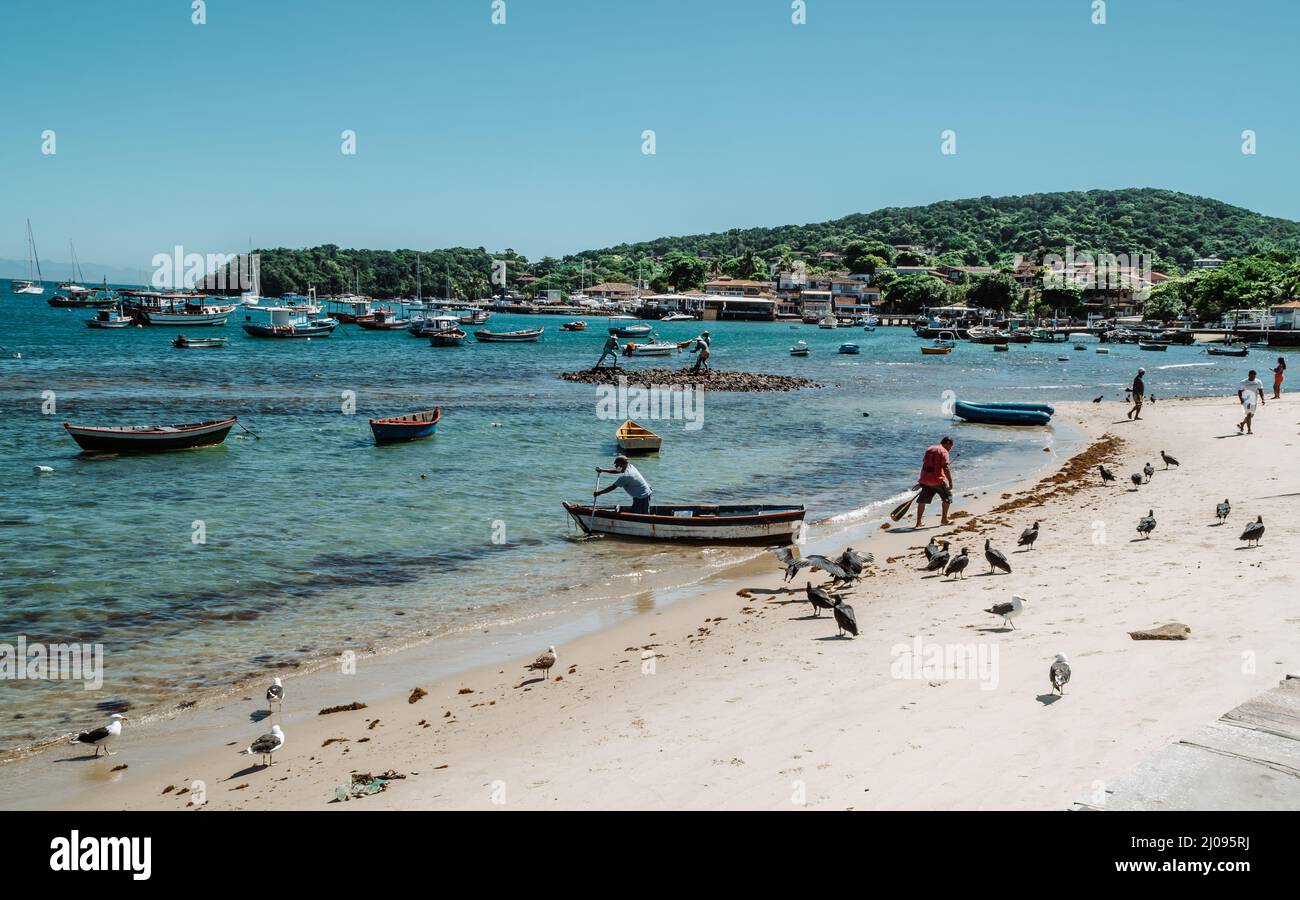 Boote und Fischer am Strand von Orla Brigitte Bardot in der Stadt Armacao dos Buzios, Brasilien Stockfoto