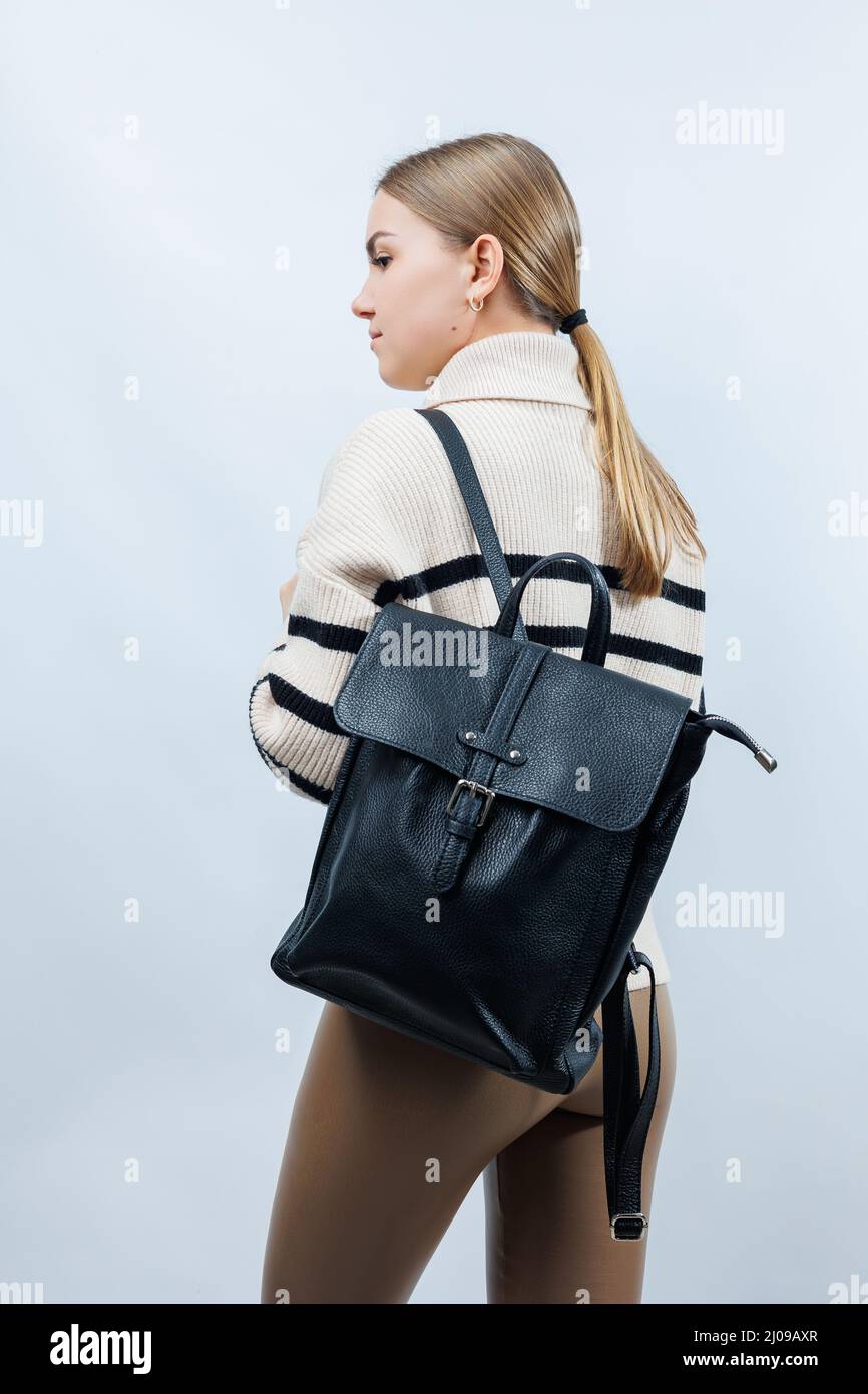 Schwarzer Rucksack auf der Schulter einer Frau, Frauenrucksack, grauer Frauenrucksack. Frauentasche isoliert auf weißem Hintergrund. Der Beutel ist auf einem isoliert Stockfoto