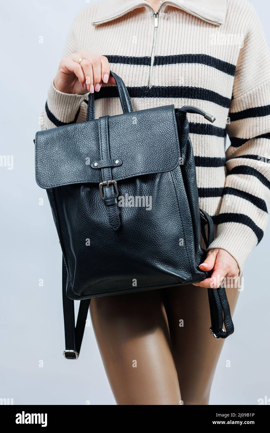 Schwarzer Rucksack auf der Schulter einer Frau, Frauenrucksack, grauer Frauenrucksack. Frauentasche isoliert auf weißem Hintergrund. Der Beutel ist auf einem isoliert Stockfoto