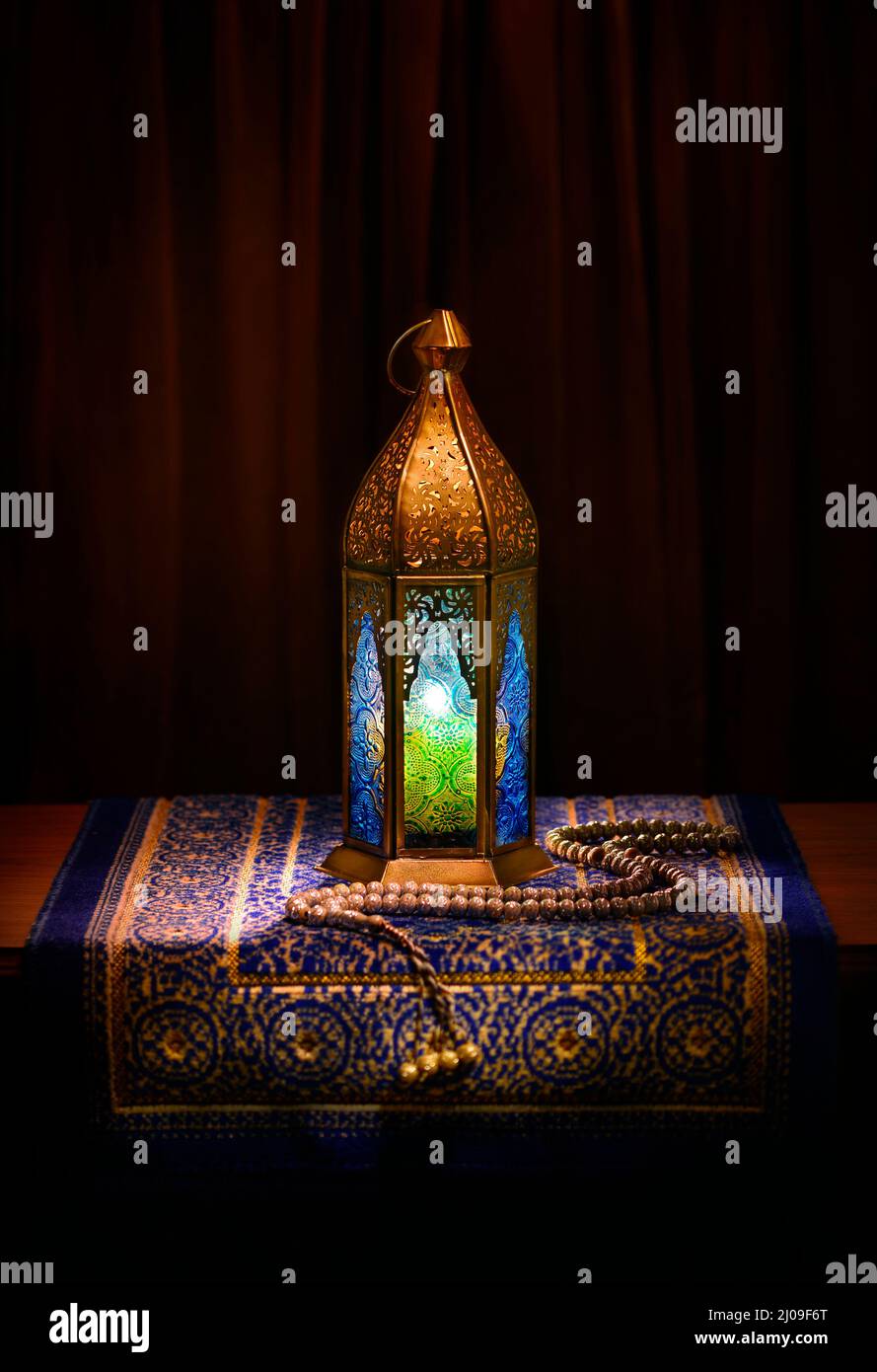 Eine goldene ornamentale Ramadan-Laterne mit Rosenkranz. Ein islamischer festlicher Hintergrund. Stockfoto