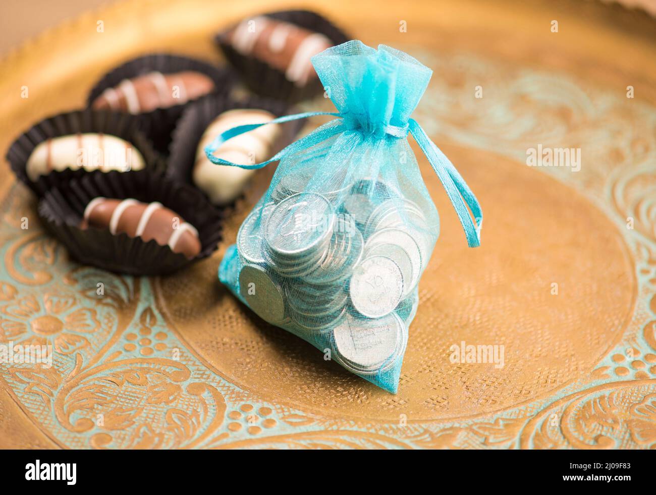 VAE-Dirham-Münzen in einem schicken Beutel mit Dattelpralinen. Geldspenden oder Wohltätigkeitsorganisationen anlässlich des Eid-Festivals. Stockfoto