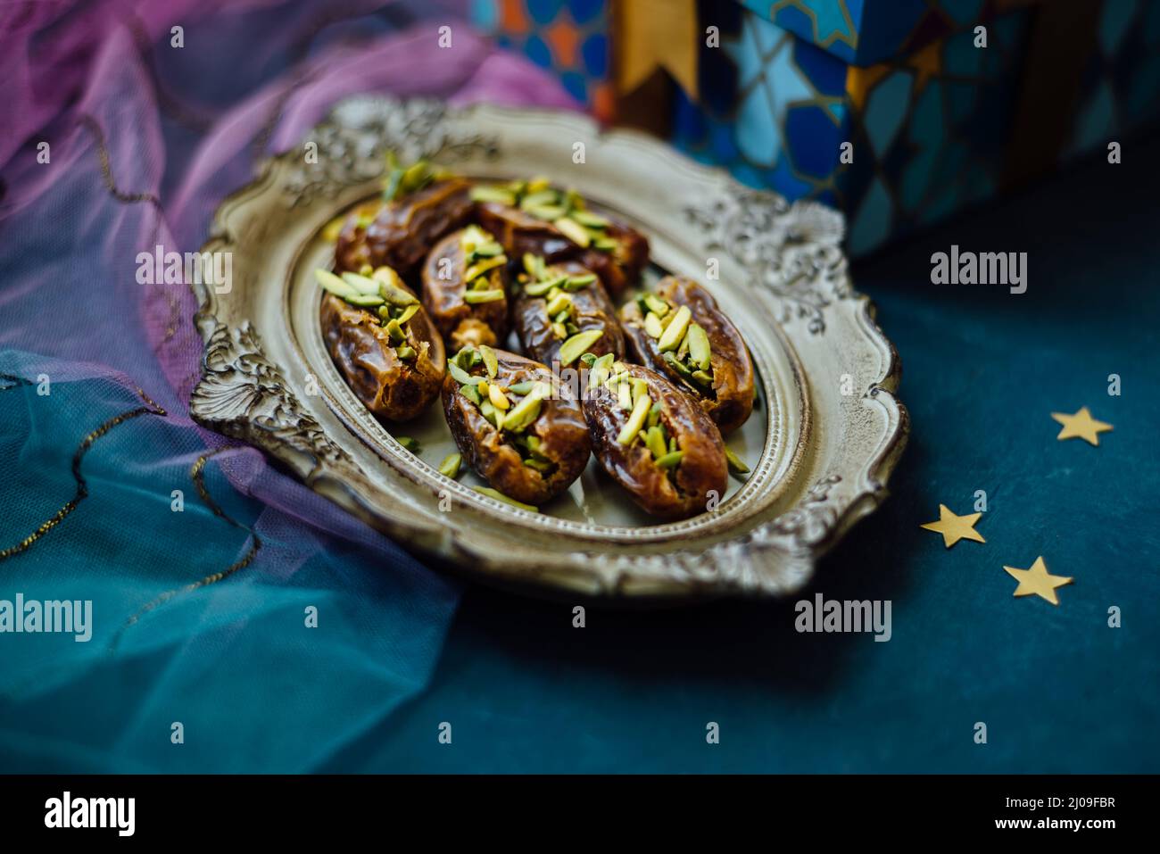 Feinste Datteln gefüllt mit Pistazien, serviert in einem dekorativen Teller. Eid Feier Foto mit schöner Geschenkbox mit Gourmet Datum Früchte. Stockfoto