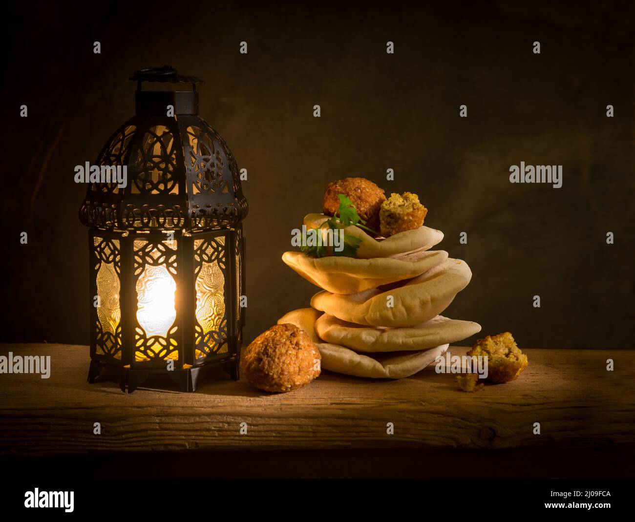 Falafel und Kuboos mit Ramadan-Laterne. Traditionelle arabische Laterne mit nahöstlicher Küche oder Speisen. Stockfoto