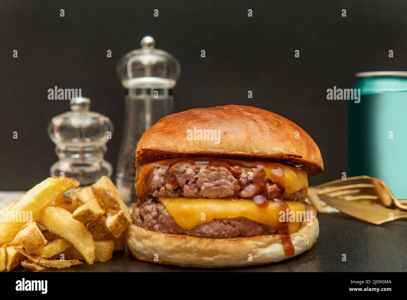 Der Double Cheeseburger mit zwei Fleischstücken gewürzt mit einem Schuss Salz und Pfeffer Ketchup, Senf und zwei Stücken geschmolzenem amerikanischen Käse mit Stockfoto