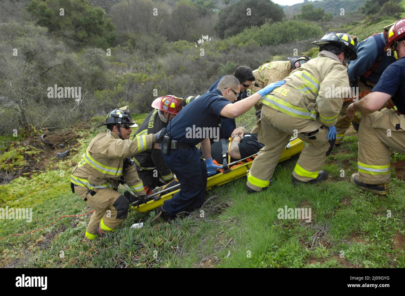 San Diego Feuerwehr-Rettungskräfte von den Stationen 20 und 36, die eine technische Rettung eines Fahrers bei einem überfahrenden Unfall im Gelände durchführen. Stockfoto