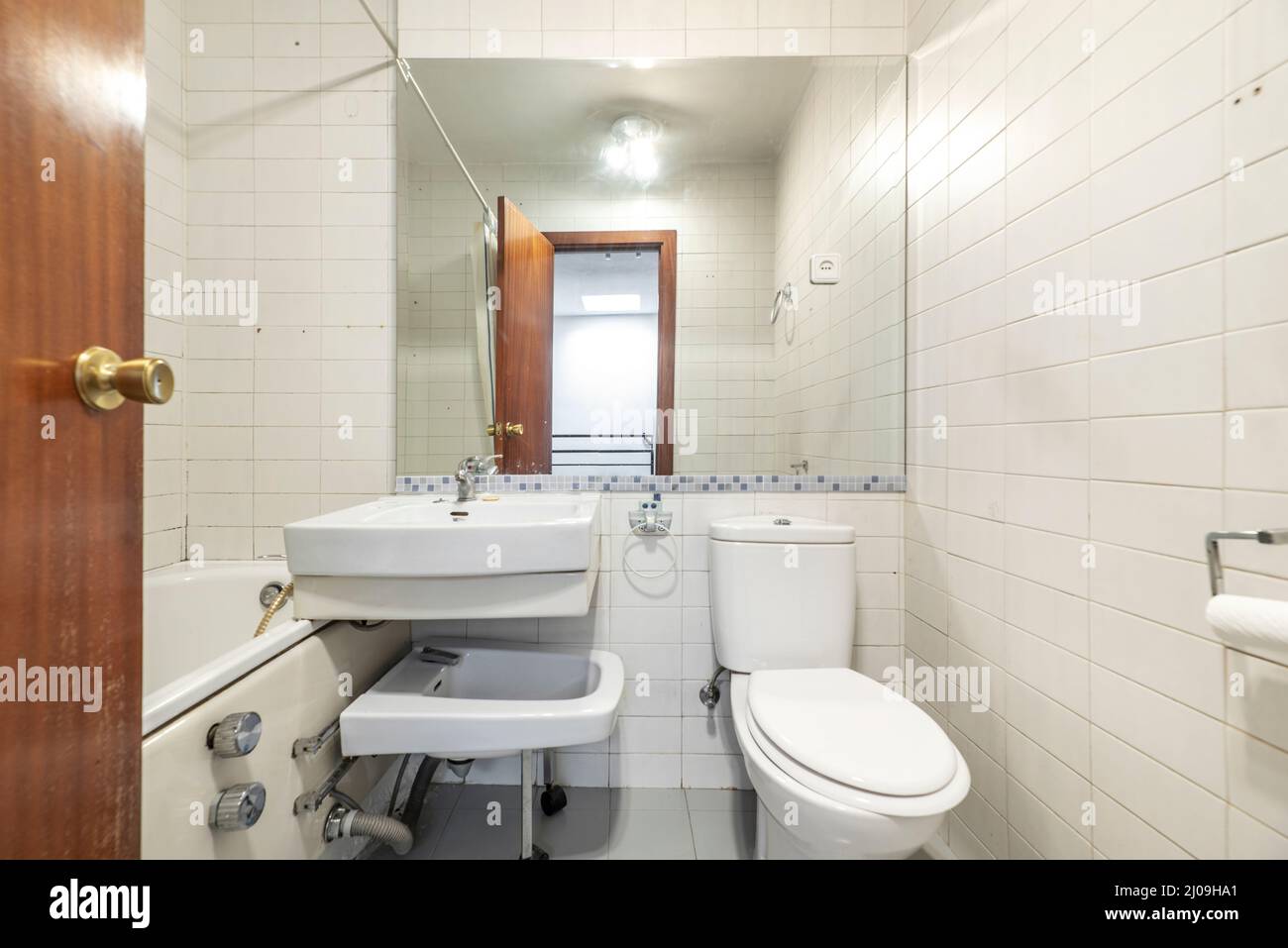 Badezimmer mit individueller Duschkabine, klappbarem Bidet und rechteckigem Spiegel in der Wand Stockfoto