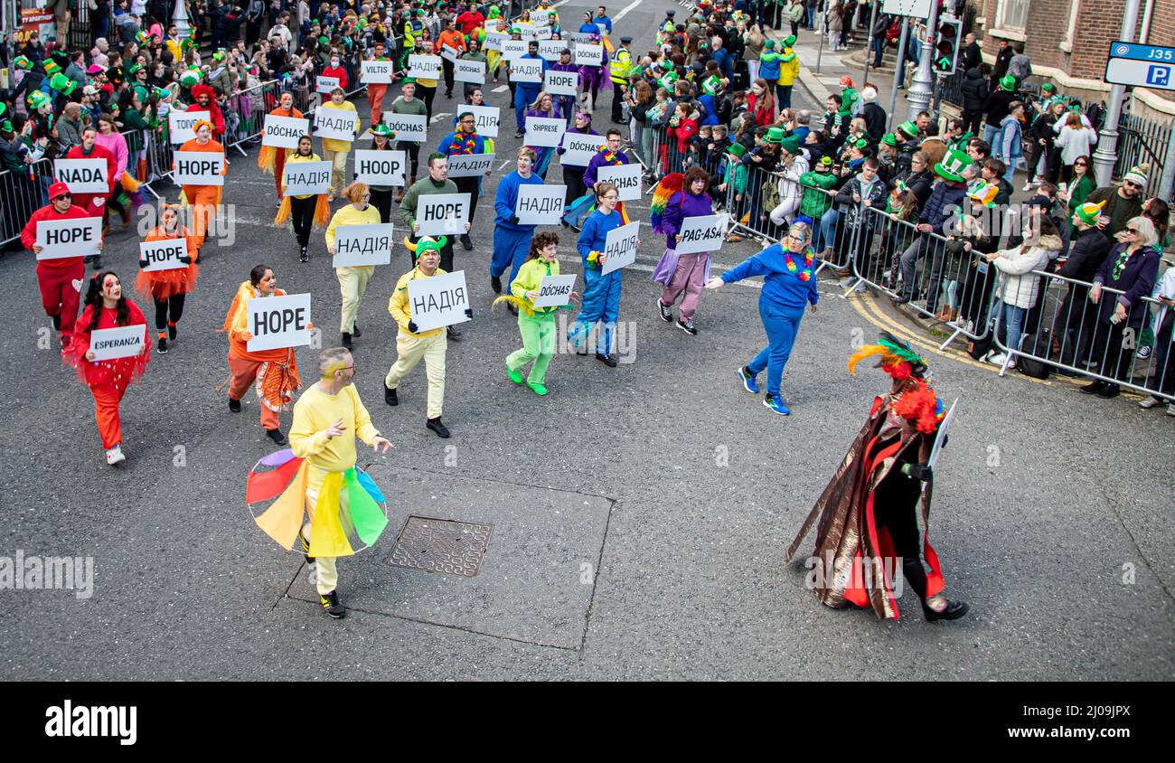 Dublin, Irland. 17. März 2022. Während der Feier halten die Teilnehmer Plakate mit Botschaften der Hoffnung und des Friedens. Drei Jahre seit Irland zum letzten Mal den St. Patrick's Day feiern konnte, markierten Dubliners und Besucher den Tag mit der Ukraine und ihren Menschen in ihren Köpfen und Herzen. Die vorherrschende Farbe der festlichen Parade durch die Straßen der Hauptstadt war nicht nur grün, sondern auch blau und gelb. Kredit: SOPA Images Limited/Alamy Live Nachrichten Stockfoto