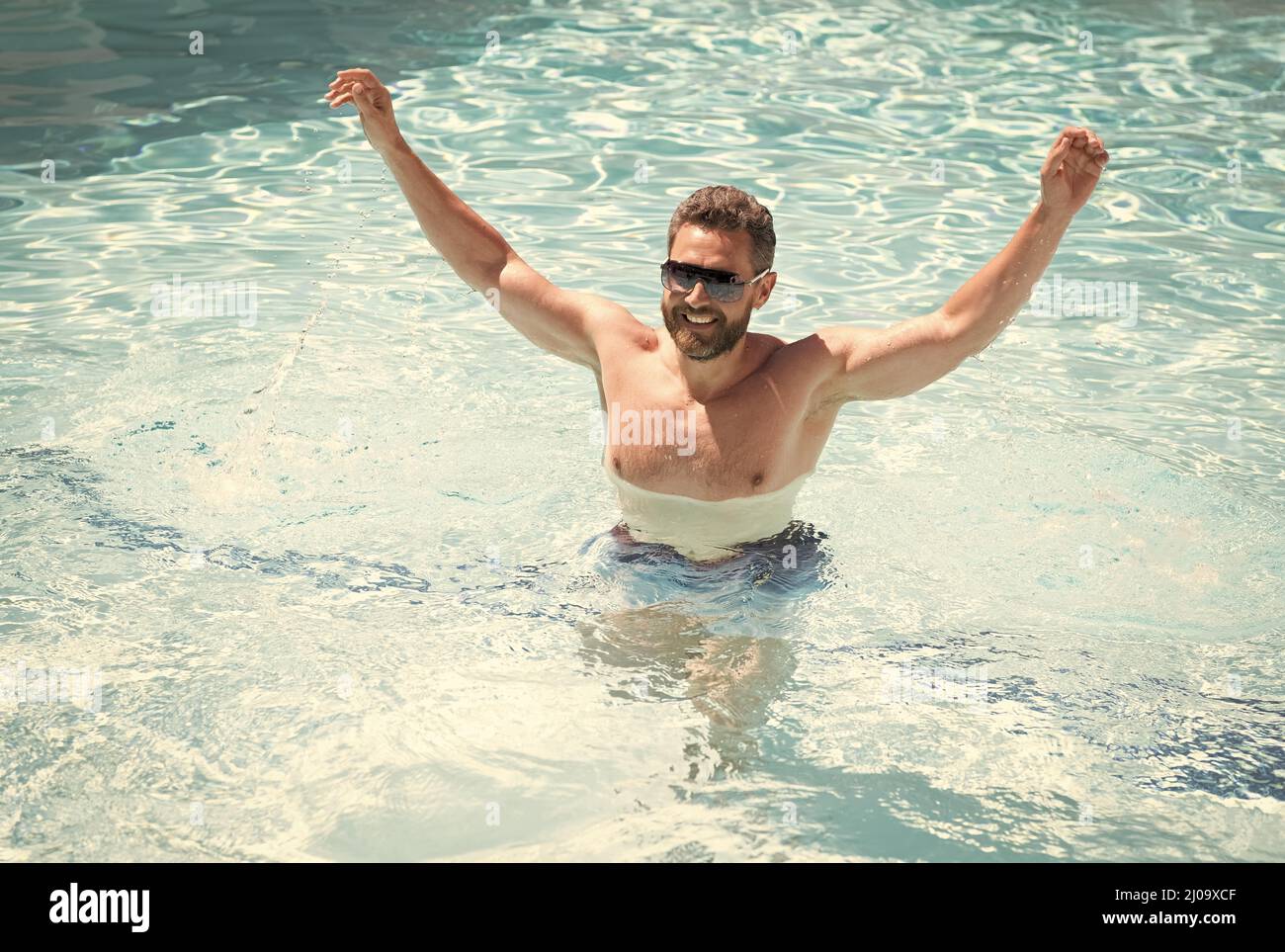 Glücklicher bärtiger Mann in Sonnenbrillen Spaß im Schwimmbad Wasser in den Sommerferien, Sommerferien. Stockfoto