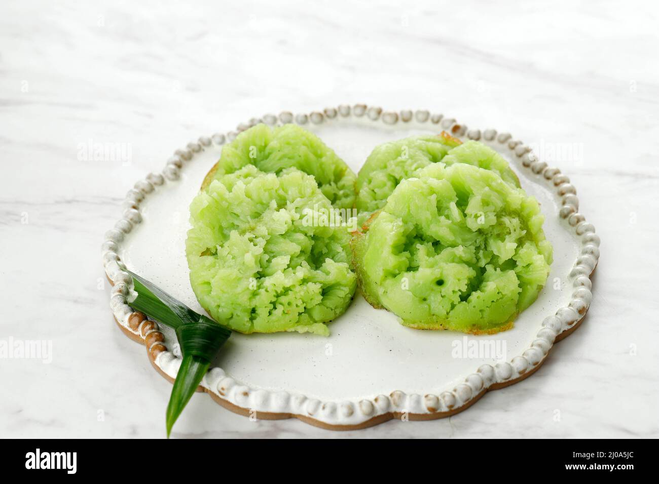 Kue Bikang oder Carabikang, traditionelle indonesische Torte, ein Varian von Jajanan Pasar. Bikang wird aus Reismehlteig und Kokosmilch hergestellt Stockfoto