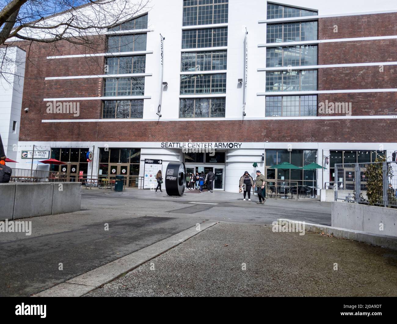 Seattle, WA USA - circa März 2022: Menschen, die an einem hellen, sonnigen Tag aus der Seattle Center Armory Food and Event Hall kommen und gehen Stockfoto