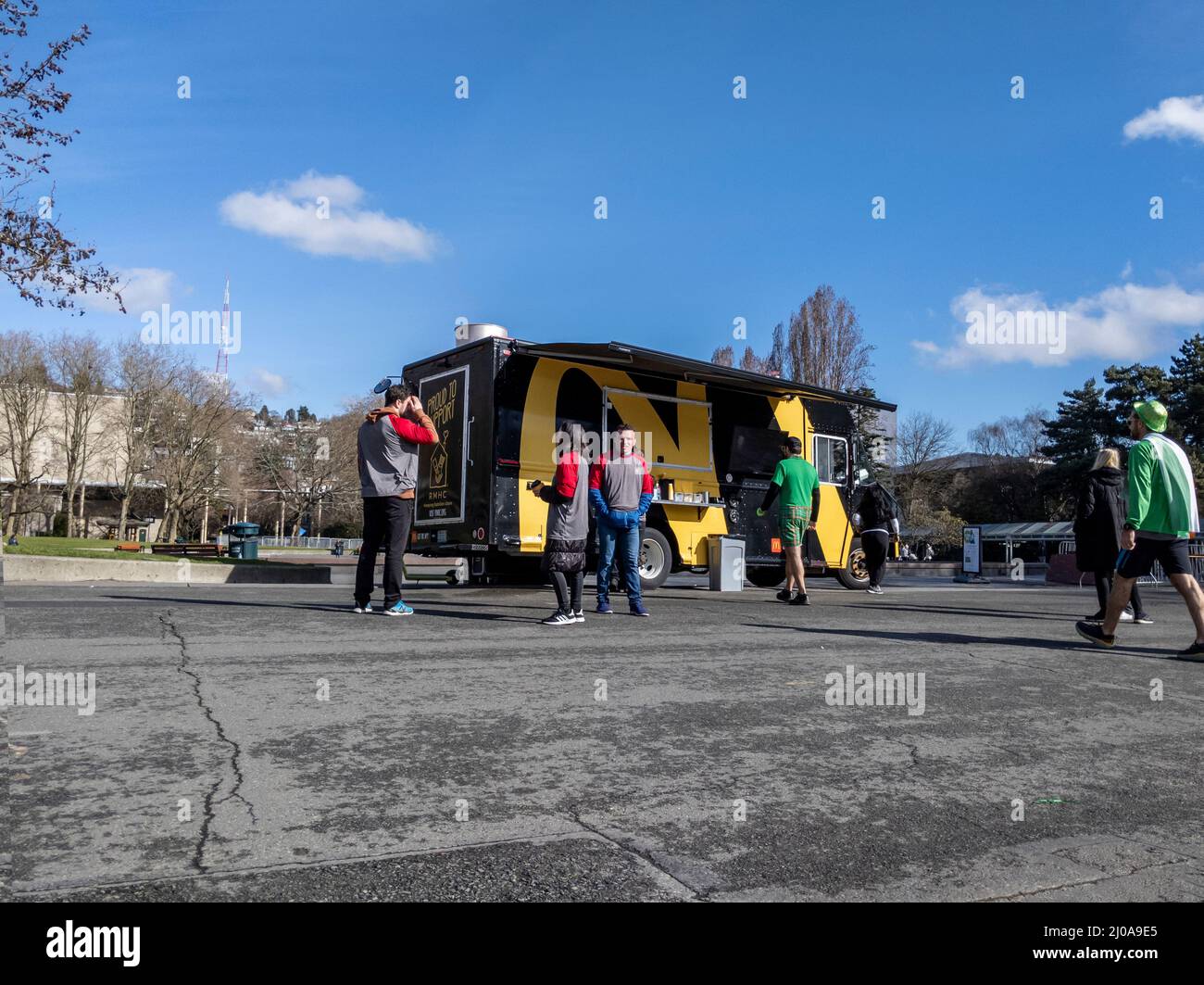 Seattle, WA USA - ca. März 2022: Straßenansicht von Menschen, die sich nach einem Marathonlauf auf einem McDonald's-Food-Truck im Seattle Center anstellen Stockfoto