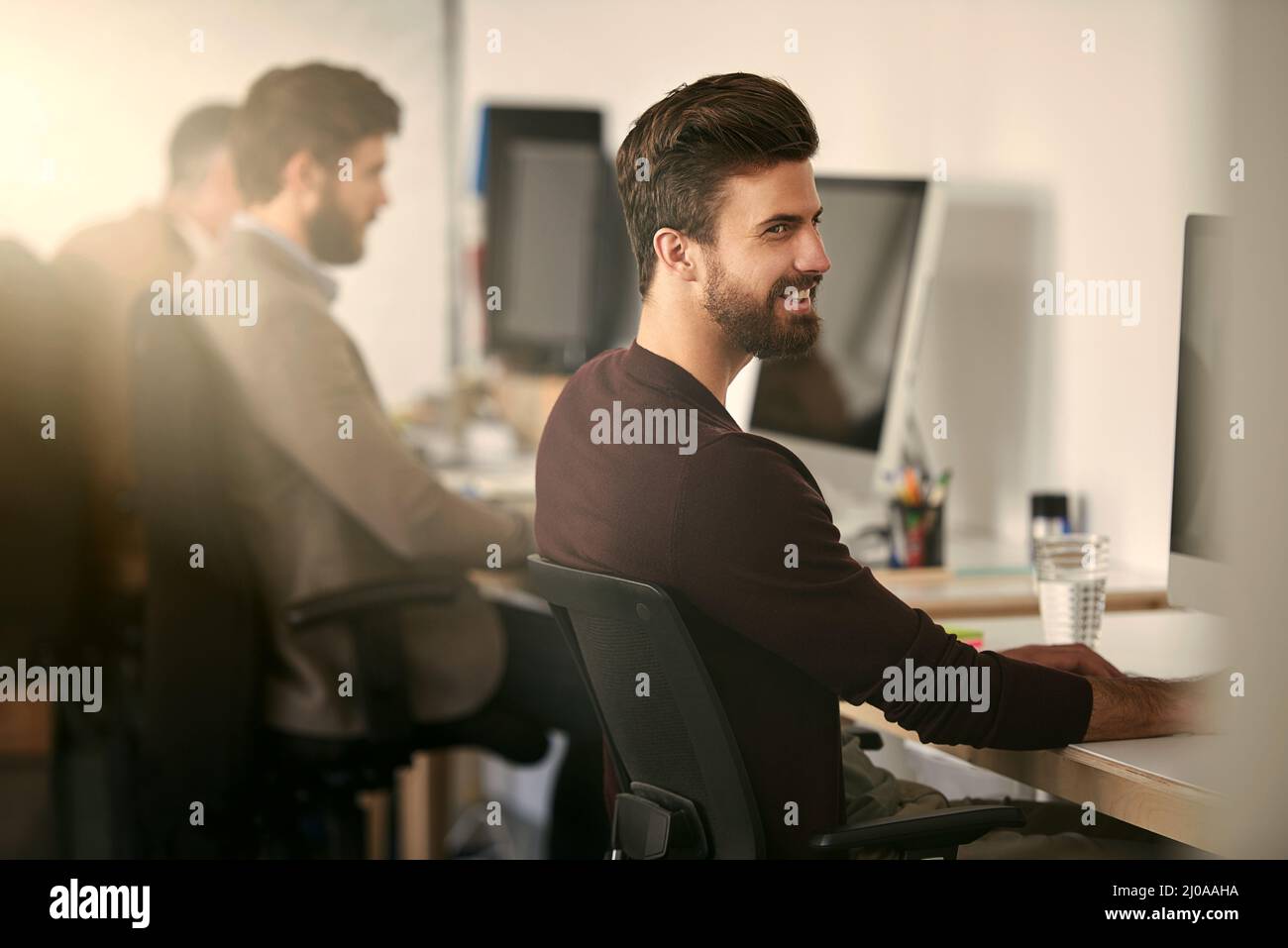 Arbeite härter als du es gestern glaubst. Aufnahme einer Gruppe von Designern, die an ihren Computern arbeiten. Stockfoto