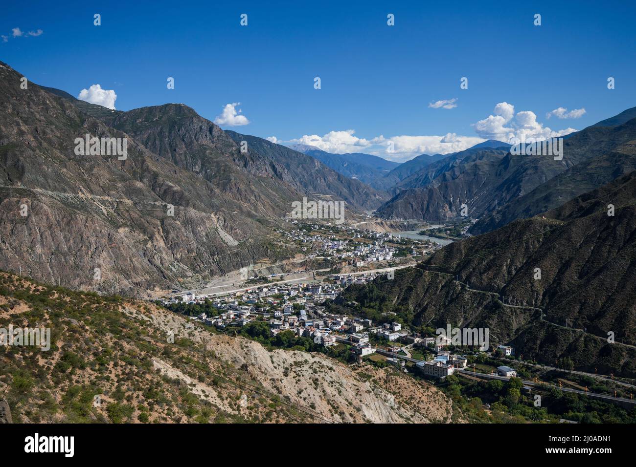 Tibetische Stadt von oben gesehen in einem Tal mit blauem Himmel Stockfoto
