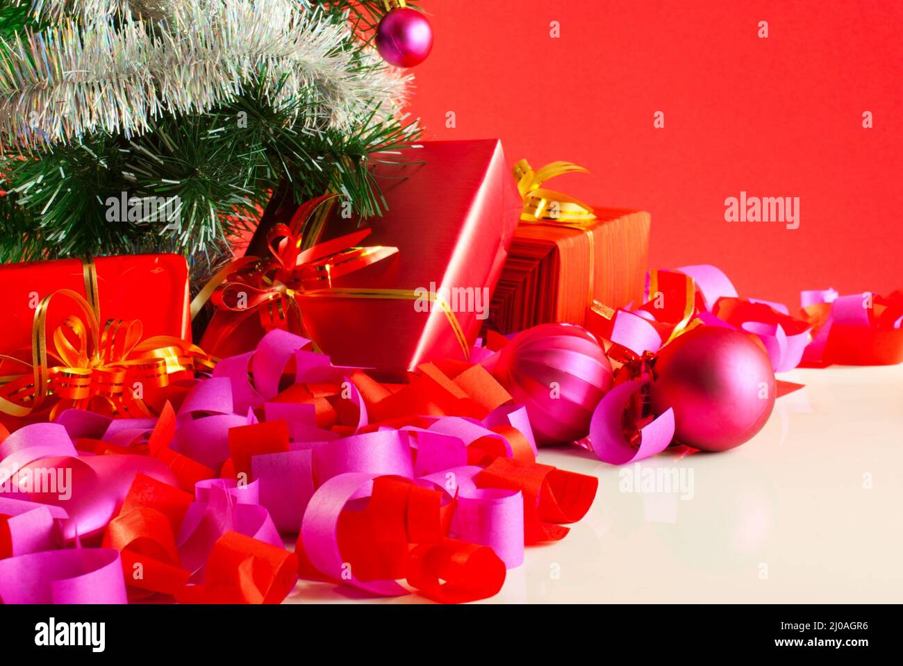 Weihnachtsgeschenke auf rotem Grund Stockfoto