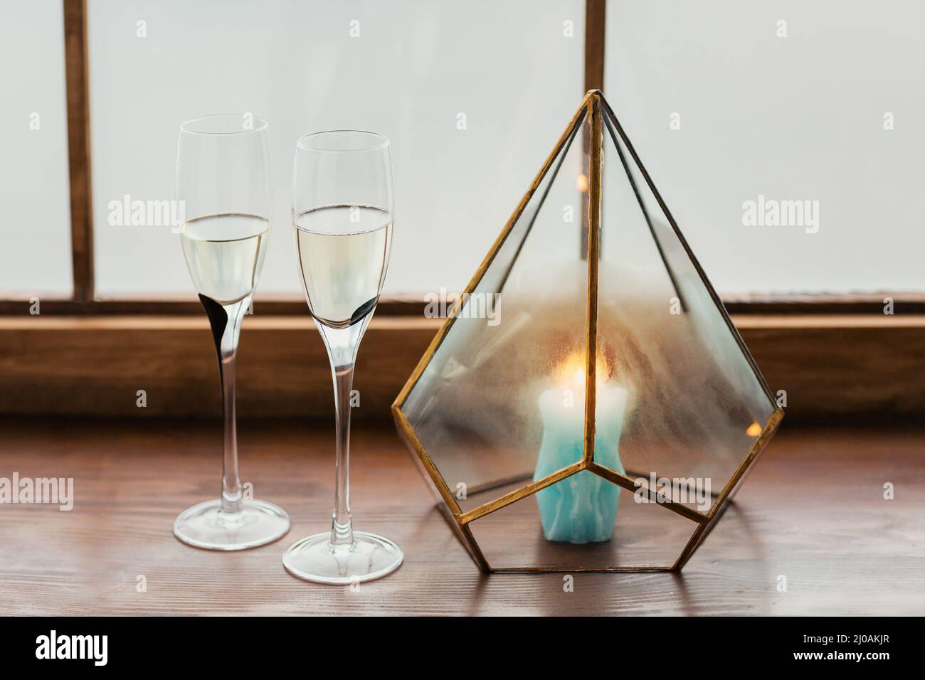 Zwei Gläser Champagner und eine Kerze auf der Fensterbank am Heiligabend Stockfoto