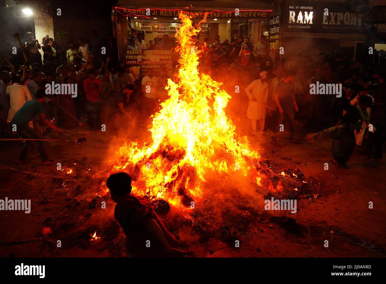 Rajasthan, Indien. 17. März 2022. Die Inder versammeln sich am Lagerfeuer, um am 17. März 2022 in Pushkar, Rajasthan, Indien, die „Holika Dahan“ zu feiern und zu beten. Holika Dahan, oder das Brennen des Dämons Holika, wird in der Nacht vor dem Holi-Fest gefeiert und soll der Flucht von Prahlad (Anhänger von lord Vishnu) vor dem Brand gedenken, wenn sie von Demoness Holika ins Feuer getragen wird. Das Lagerfeuer symbolisiert den Sieg des Guten über das Böse. Foto von ABACAPRESS.COM Quelle: Abaca Press/Alamy Live News Stockfoto