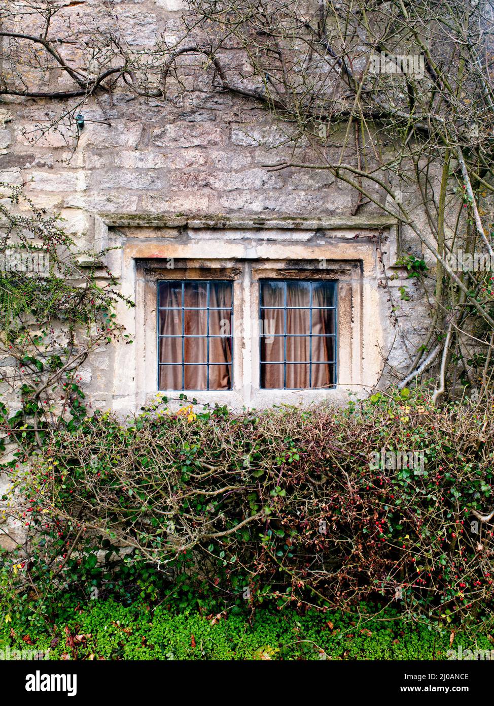 Eingezäunte Fenster auf einem Steinhaus Stockfoto