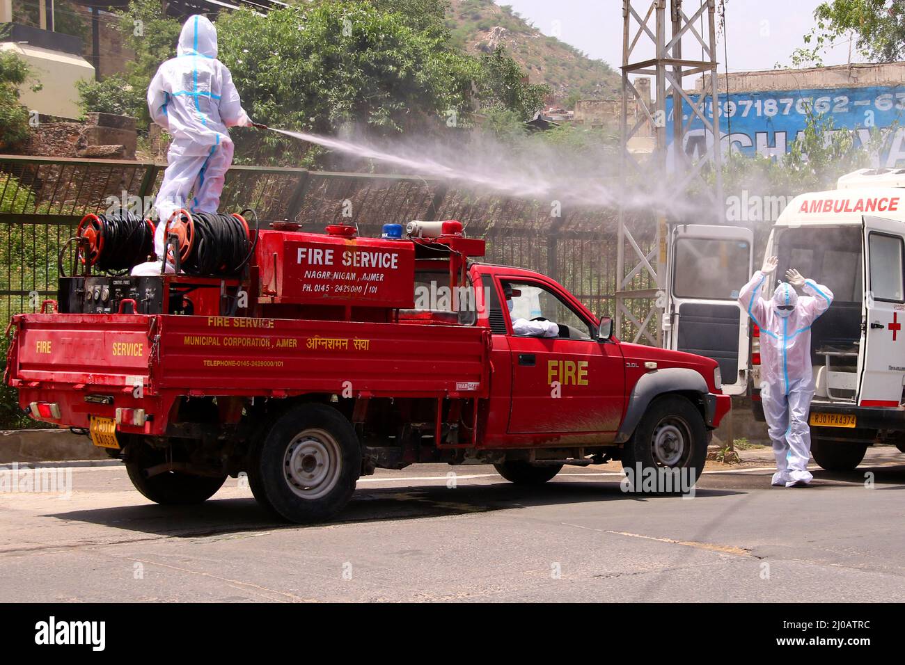 Indischer Stadtarbeiter sprüht Desinfektionsmittel auf seine Kollegen, nachdem sie am 19. Juni 2020 den Leichnam eines COVID-19-Opfers in einem Krematorium in Ajmer, Rajasthan, Indien, eingeäschert haben. Foto von ABACAPRESS.COM Stockfoto