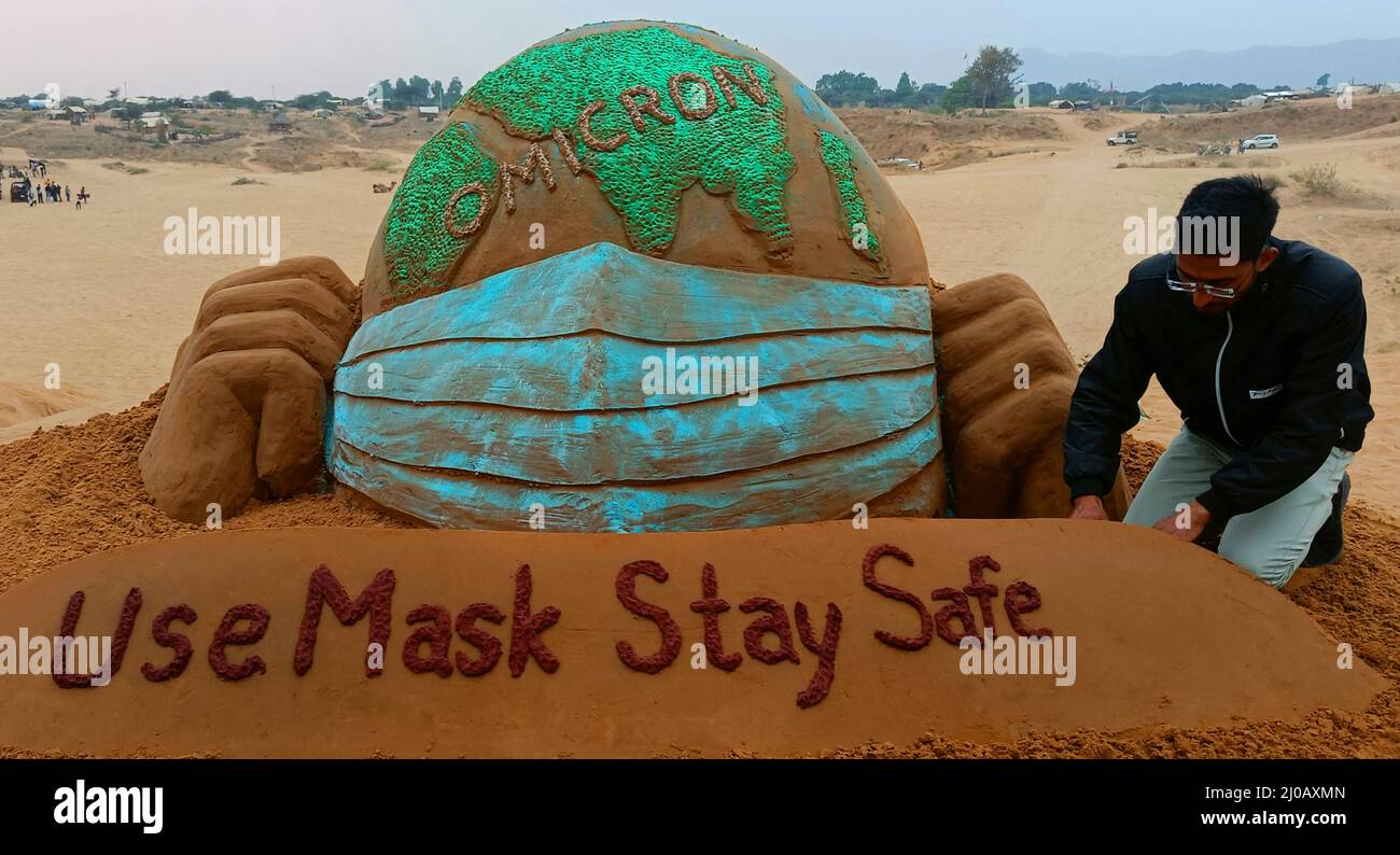 Der indische Sandkünstler Ajay Rawat kreiert am 26. Dezember 2021 in der Wüste von Pushkar, Rajasthan, Indien, Sandkunst für die Aufmerksamkeit auf das Coronavirus. Foto von ABACAPRESS.COM Stockfoto