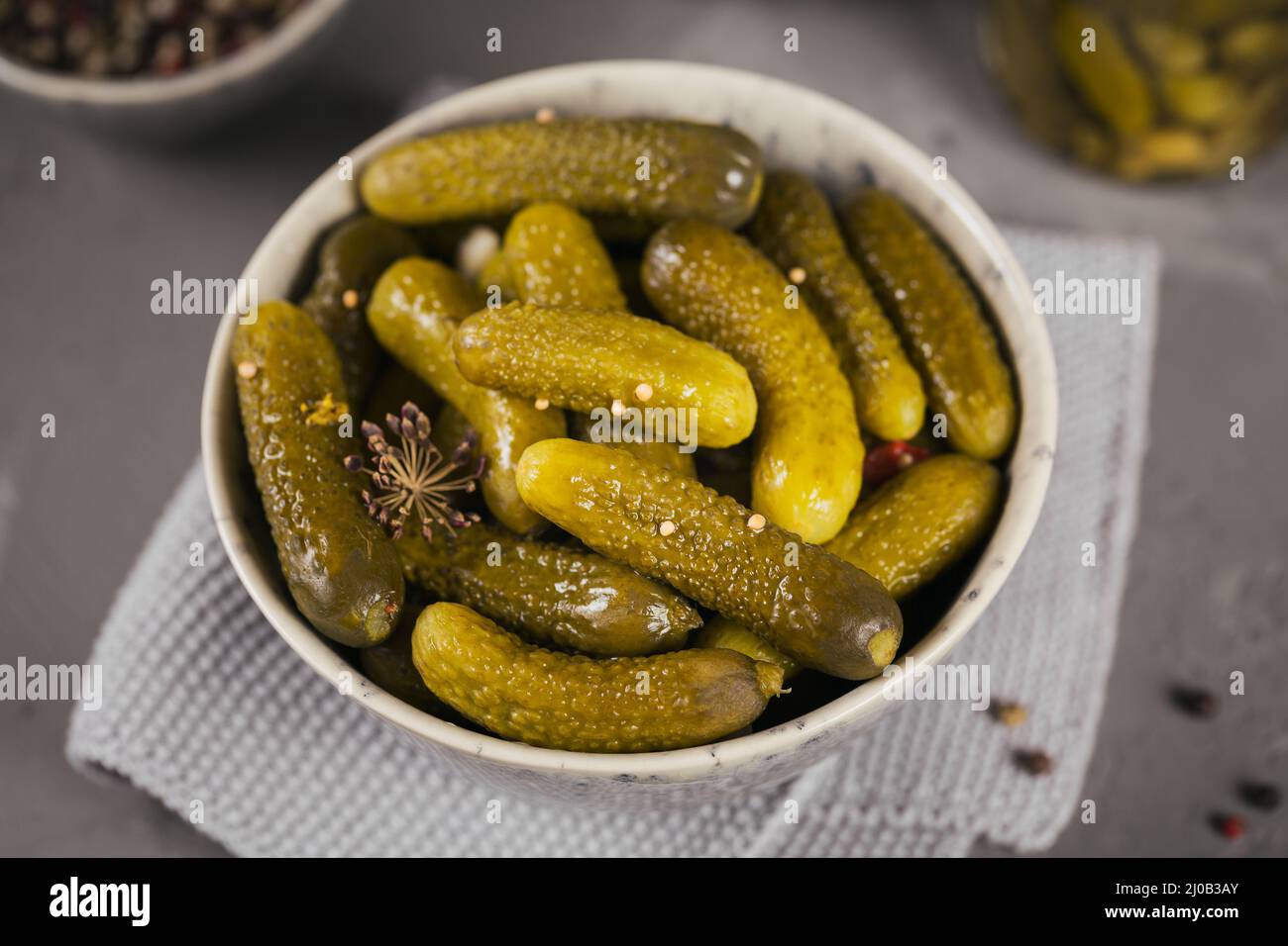 Teller mit Gurken, eingelegte Gurken auf grauem Betongrund. Sauberes Essen, vegetarisches Konzept Stockfoto