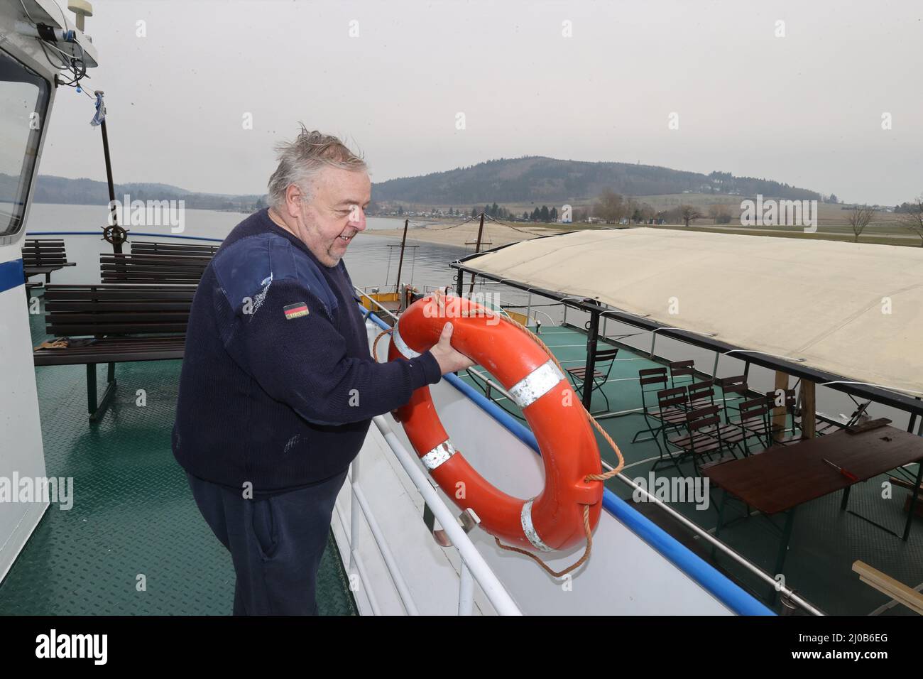 Saalburg Ebersdorf, Deutschland. 17. März 2022. Kapitän Klaus-Peter Pretzsch legt die Rettungsschwimmer in den Halter an Bord des Schiffes 'Thüringer Meer'. Die drei Schiffe der Reederei Stausee liegen an den Ufern des Bleiloch-Staudamms. Hier sind sie auf die Saison vorbereitet. (To dpa: Sieben Zeichen des Frühlingserwachens in Thüringen) Quelle: Bodo Schackow/dpa-zentralbild/dpa/Alamy Live News Stockfoto