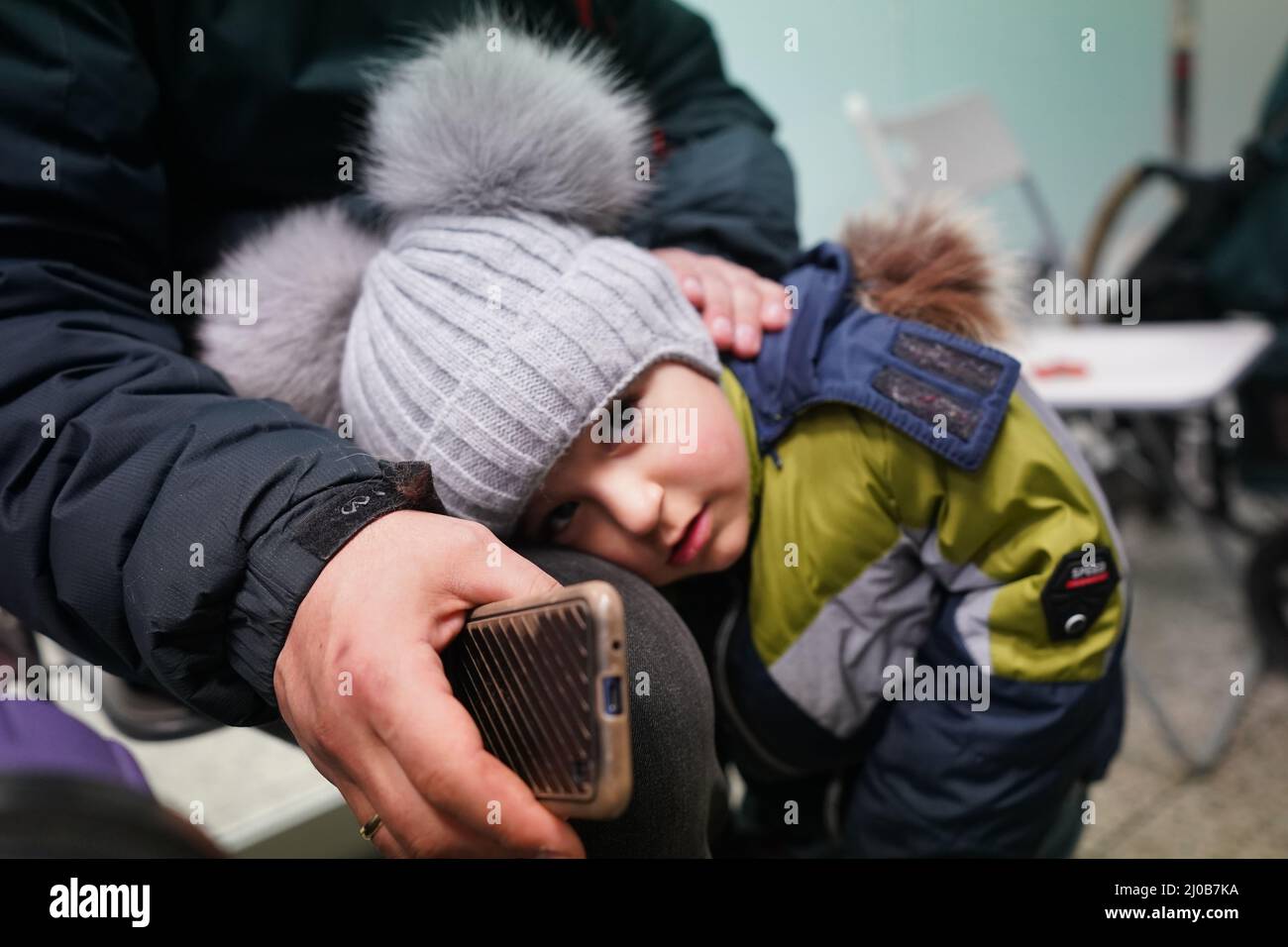 Hamburg, Deutschland. 18. März 2022. Der dreijährige Levon und sein Vater Edgar, Flüchtlinge aus der ukrainischen Stadt Poltawa, sitzen in einem Zimmer im Arbeiter-Samariter-Bund (ASB) im Hauptbahnhof. ASB-Mitarbeiter und Freiwillige sowie Übersetzer begrüßen die ukrainischen Flüchtlinge bei ihrer Ankunft am Hamburger Hauptbahnhof. Den Flüchtlingen werden Getränke und Essen sowie Informationen zur Anmeldung, zur freien Unterkunft oder Weiterreise zur Verfügung gestellt. Kredit: Marcus Brandt/dpa/Alamy Live Nachrichten Stockfoto