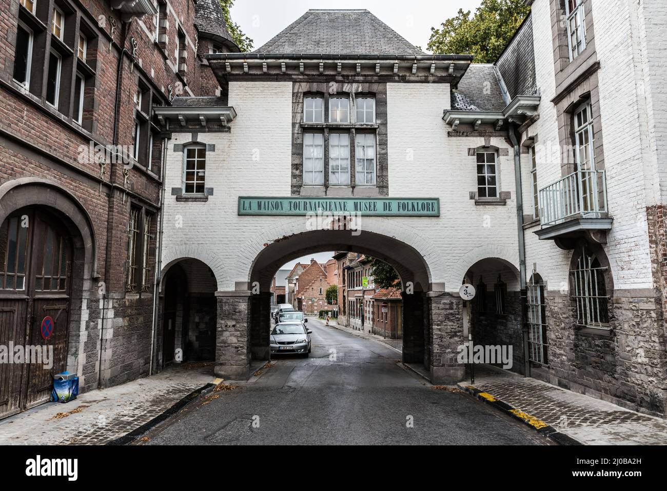Tournai Doornik, Wallonische Region - Belgien - 08 14 2019 kleine mittelalterliche Straße und altes Stadttor, jetzt das Tournai-Haus Stockfoto
