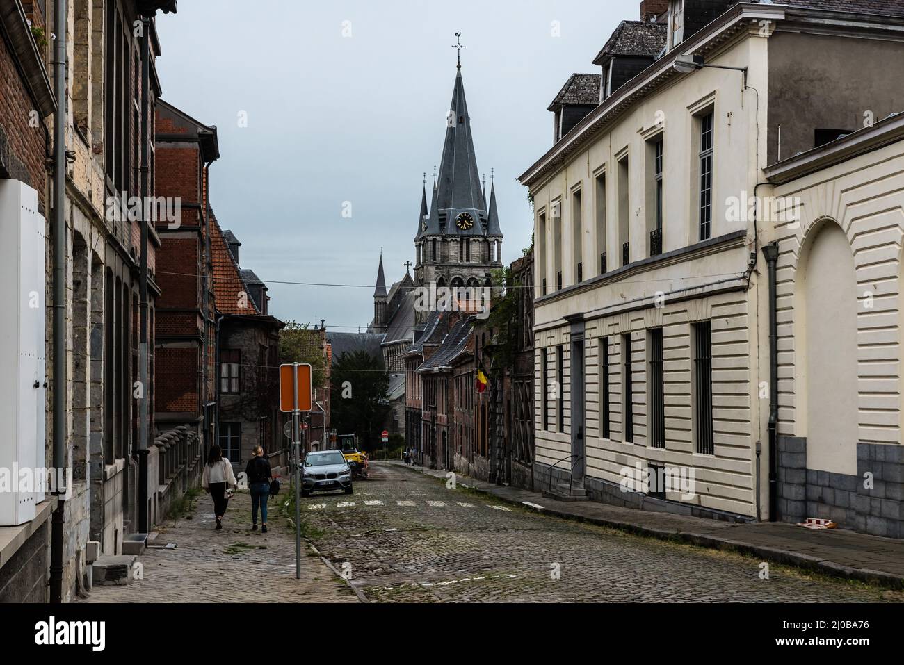 Tournai Doornik, Wallonische Region - Belgien - 08 14 2019 Blick auf eine alte gepflasterter Straße mit der St.-Johannes-Kirche im Hintergrund Stockfoto