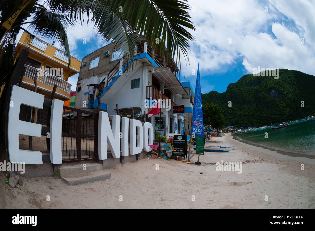 El Nido Schild am Strand vor der Häuser Stockfoto