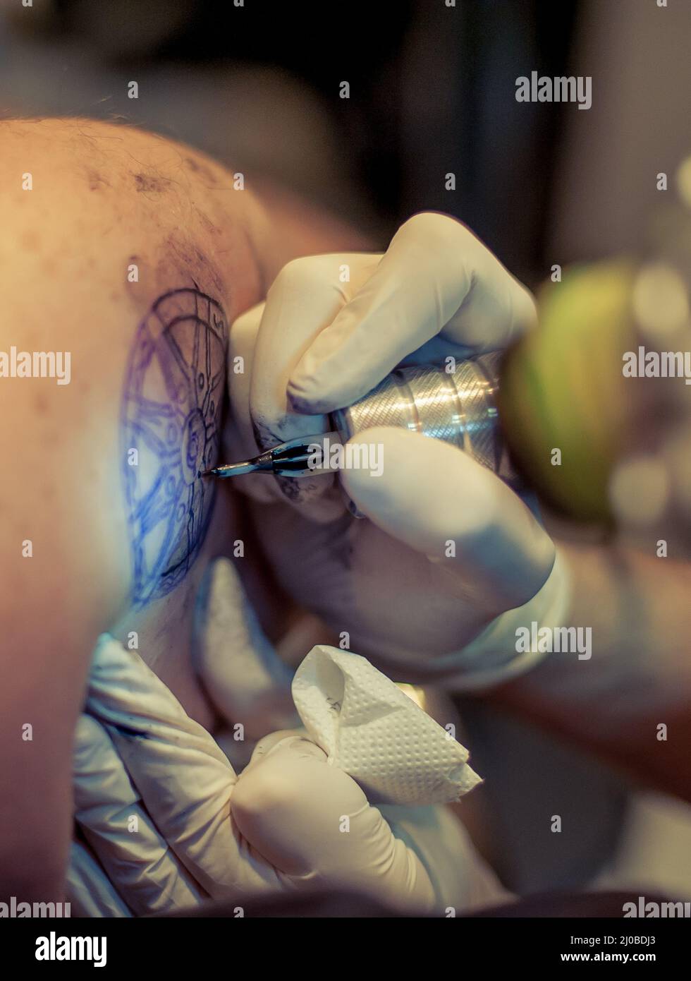 Master Tattoo zeichnet die blaue Farbe auf dem Kunden Tattoo Stockfoto