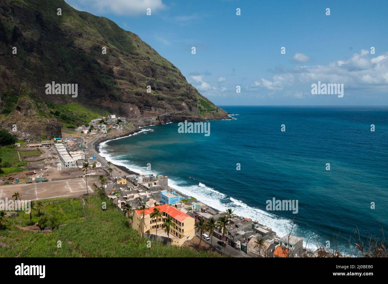 Kleine Stadt mit Fußballplatz an der Strandküste mit schwarzen Steinen auf der Insel Kap verde Stockfoto