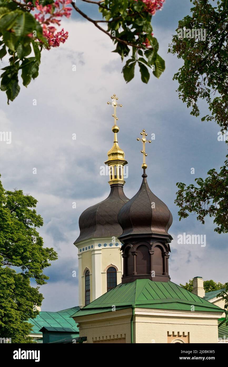 Kloster der Heiligen Dreifaltigkeit von St. Jonas des 19.. Jahrhunderts in Kiew unter den blühenden Kastanienbäumen Stockfoto