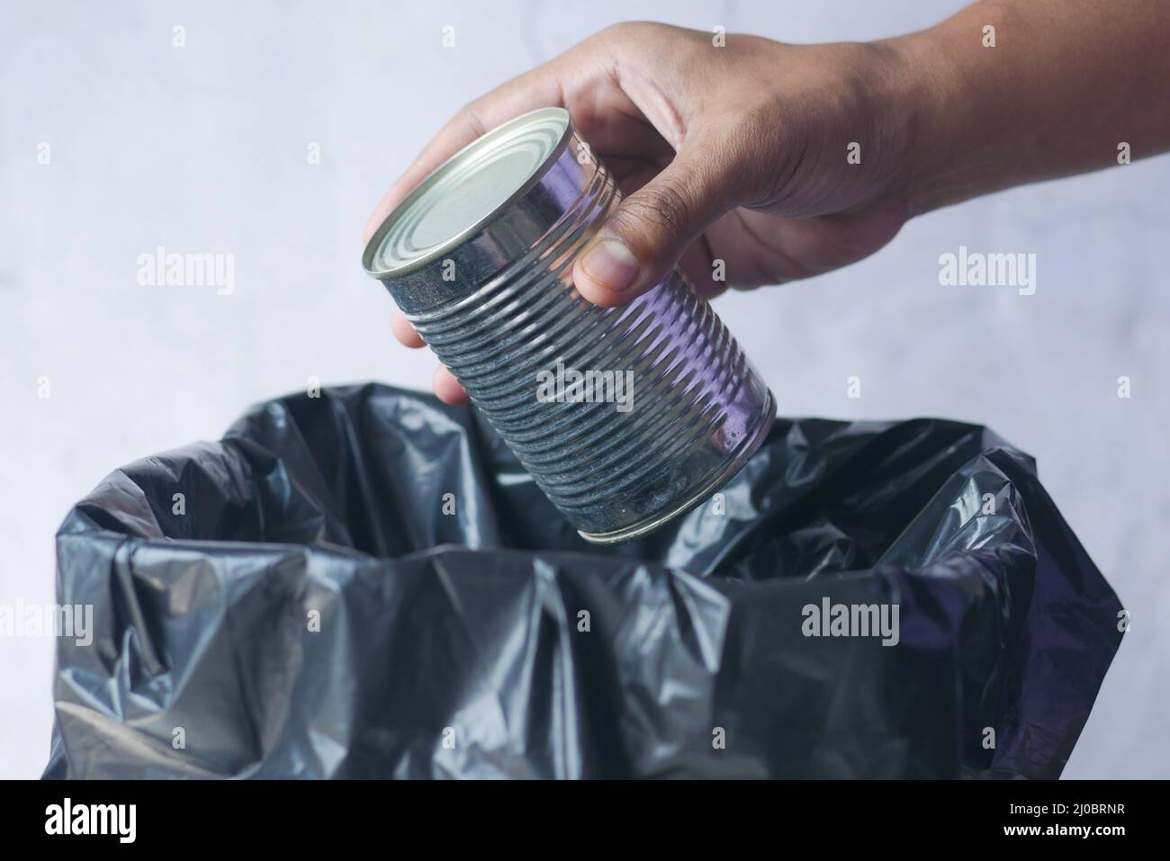 Werfen Sie die Dose in einen Abfalleimer Stockfoto