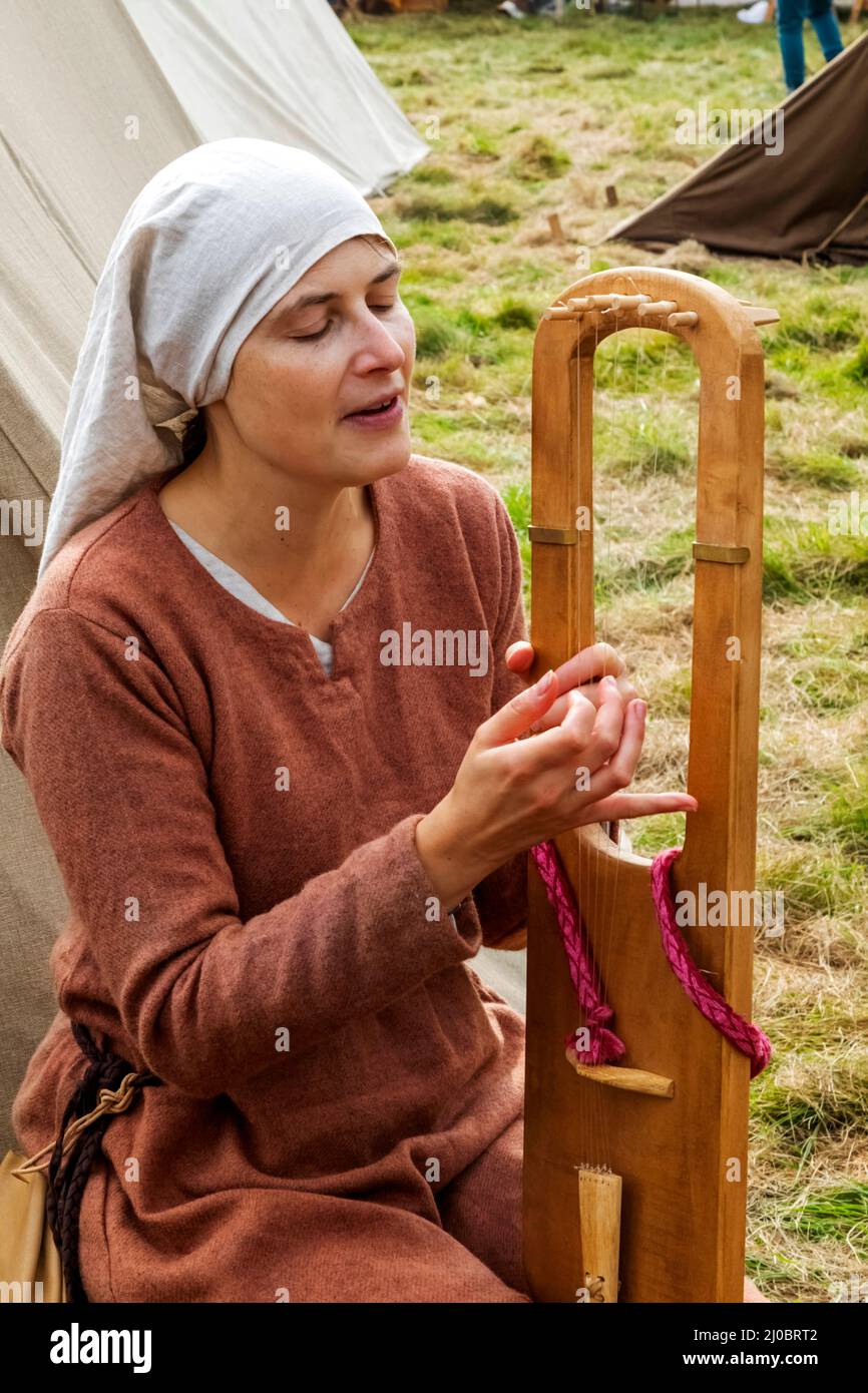 England, East Sussex, Battle, The Annual Battle of Hastings 1066 Re-enactment Festival, Teilnehmerin im mittelalterlichen Kostüm, die Medieva spielt Stockfoto