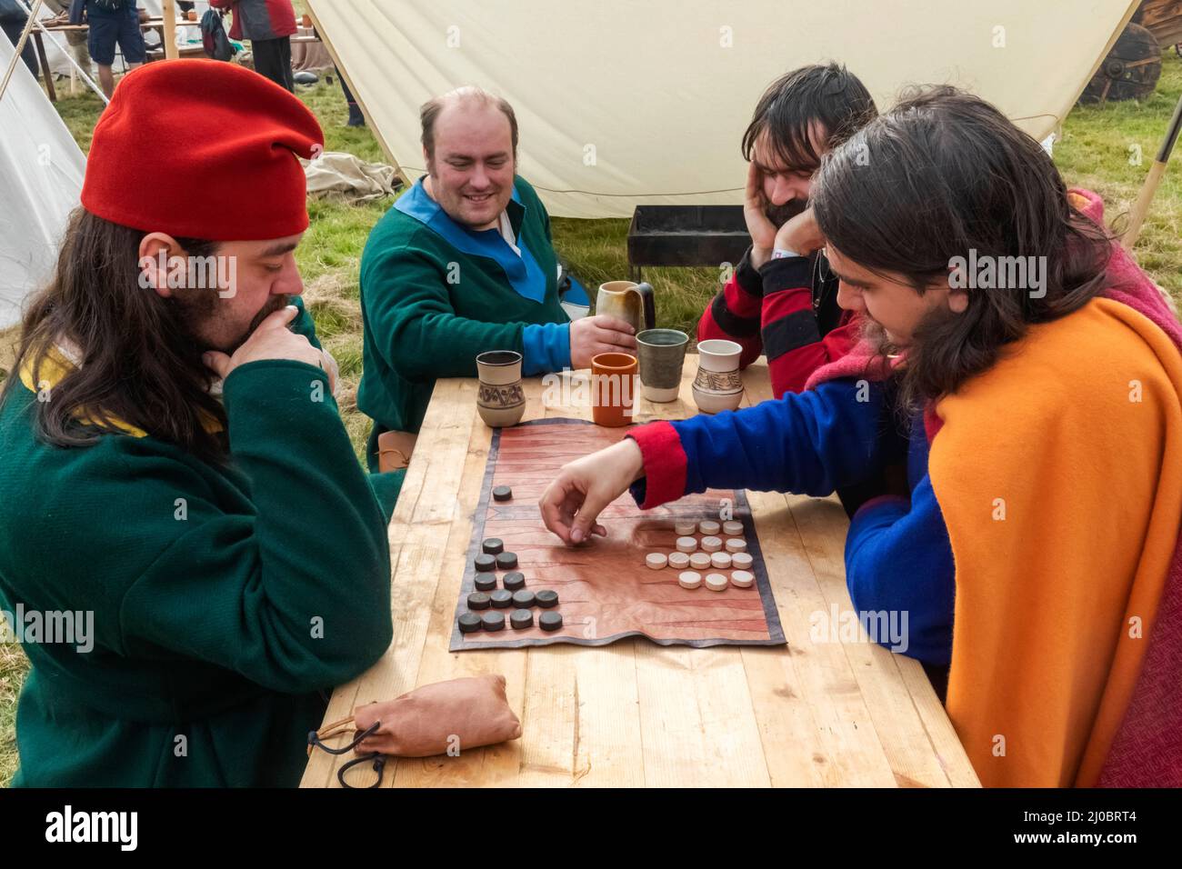 England, East Sussex, Battle, The Annual Battle of Hastings 1066 Re-enactment Festival, Teilnehmer in mittelalterlichen Kostümen, die Backgammon spielen Stockfoto